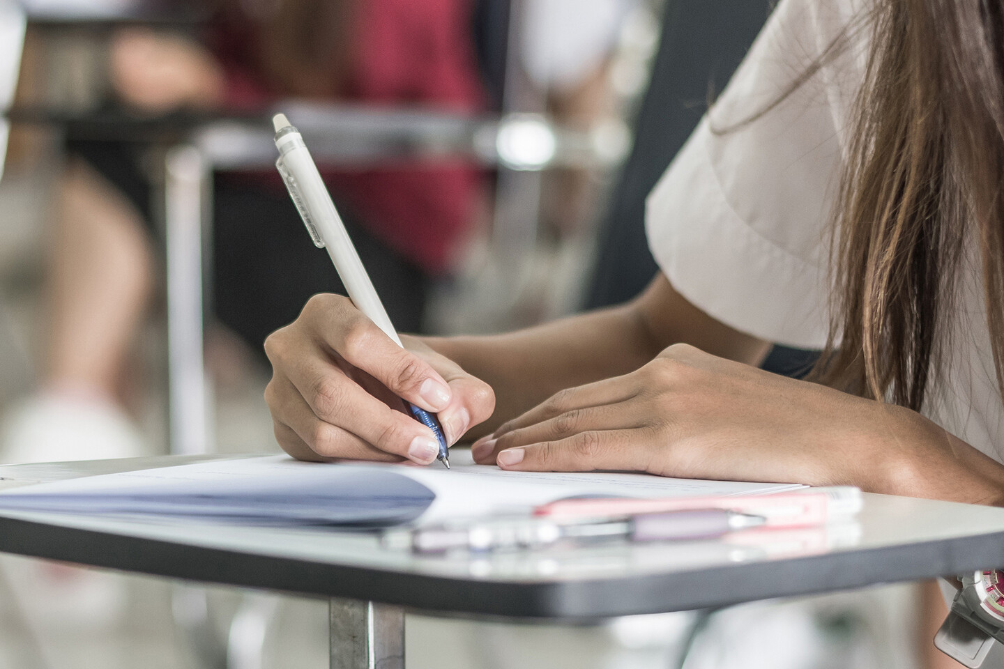 Student holding pencil to paper pamphlet.