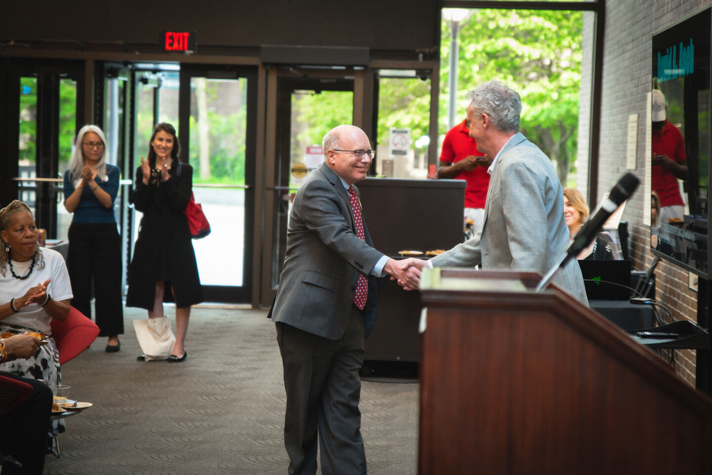 David Asch shakes John McInerney's hand.