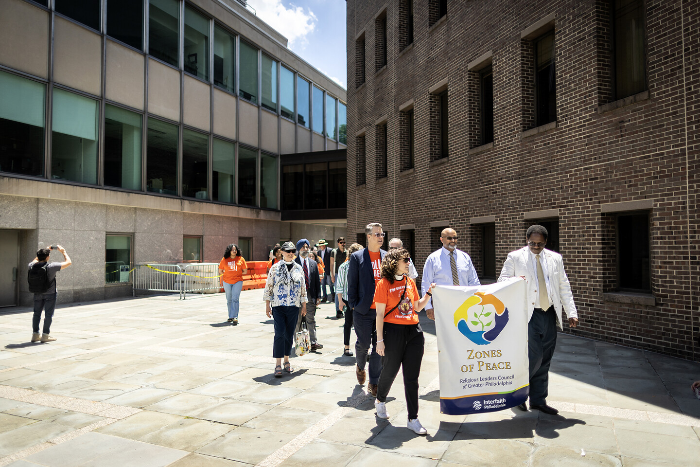 Group of people wearing orange and processing out of the Annenberg plaza.