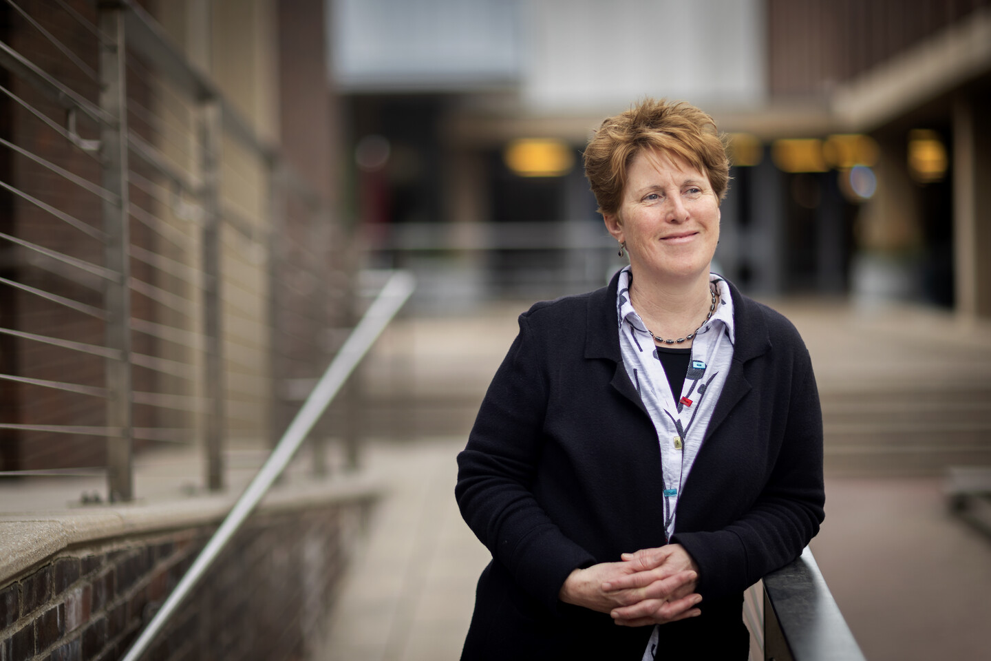 Amy Hillier leans against a railing at the School of Social Policy & Practice