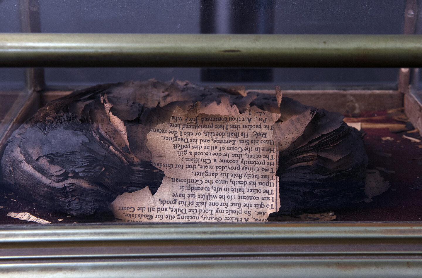 a close-up of a readable portion of the burned Shakespeare Folio in a glass case