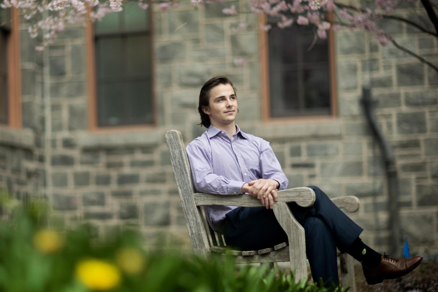 William Reason sitting on a bench outside. 