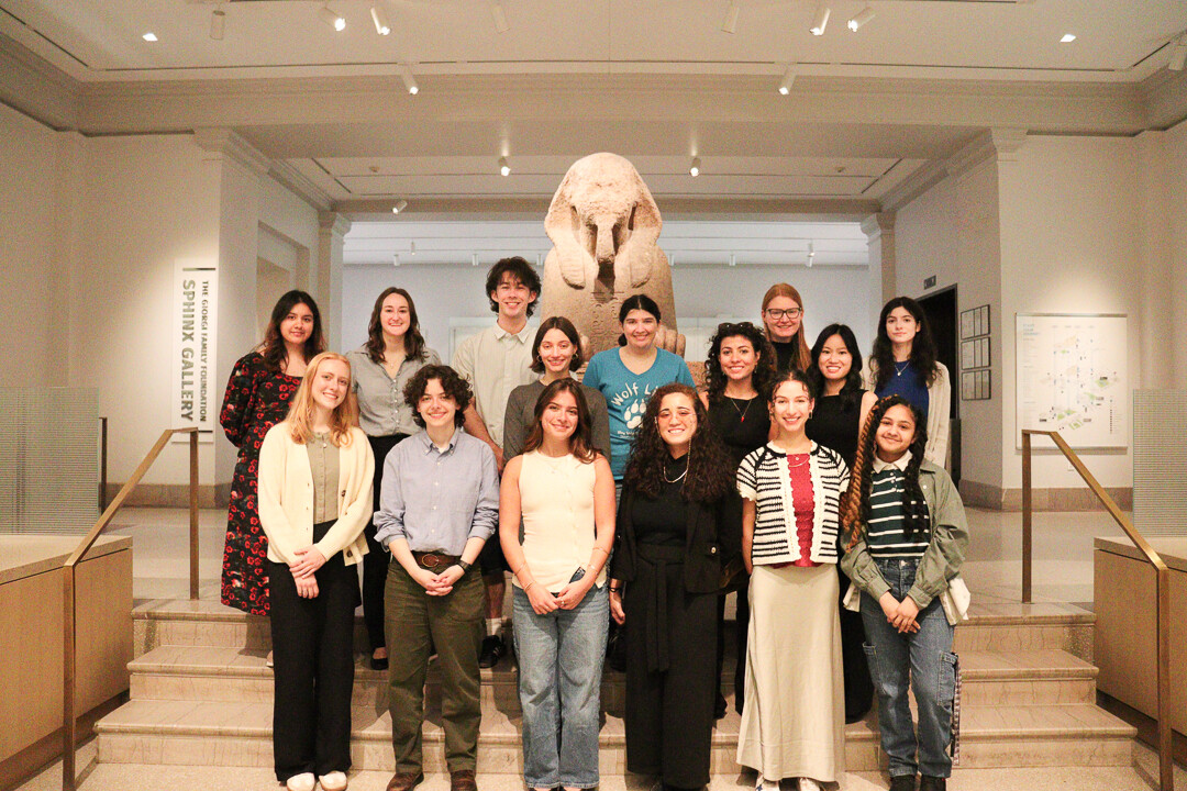 15 students standing in front of the Sphinx at the Penn Museum