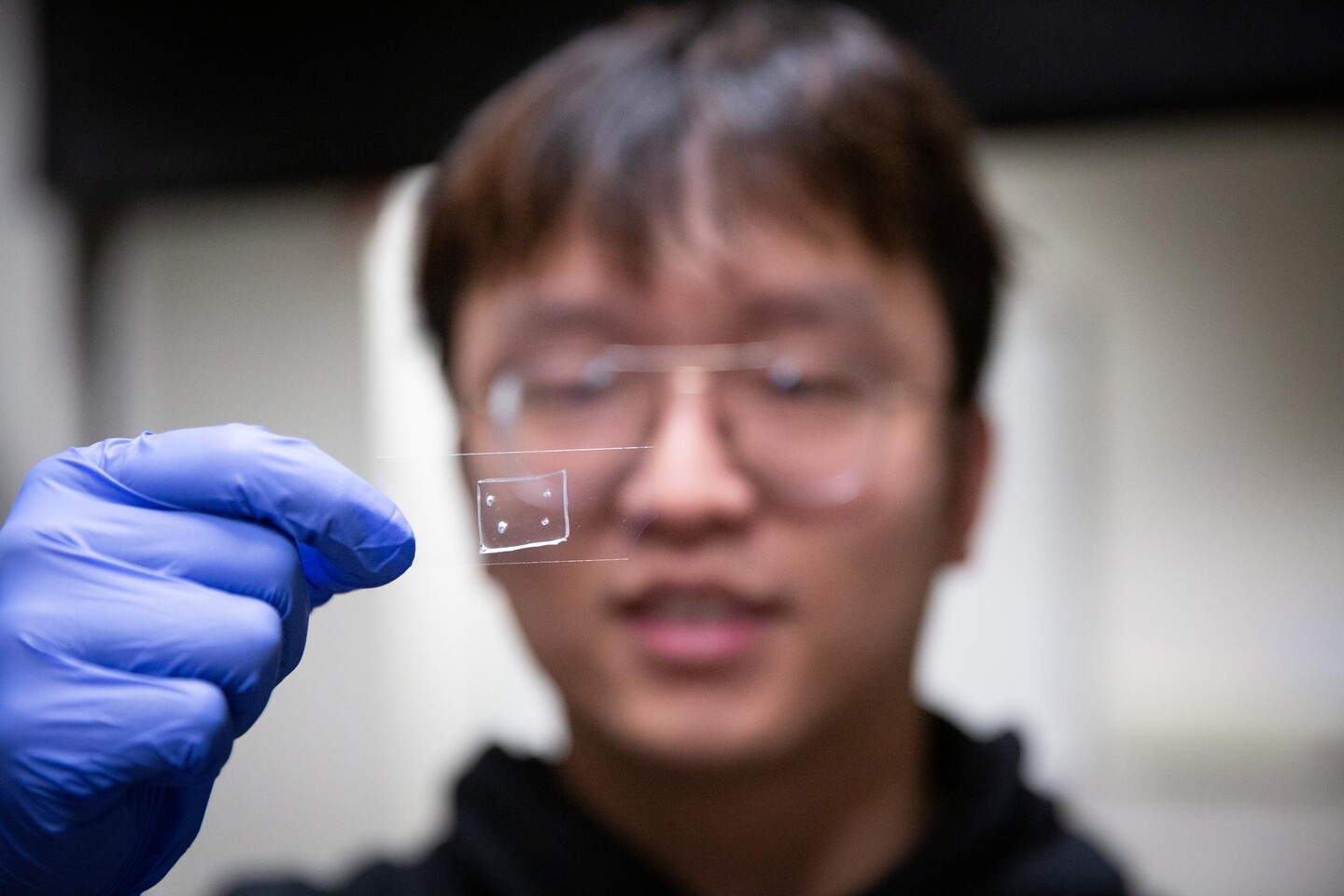 PhD student Ran Tao holding a nanofabricated microstrucure.