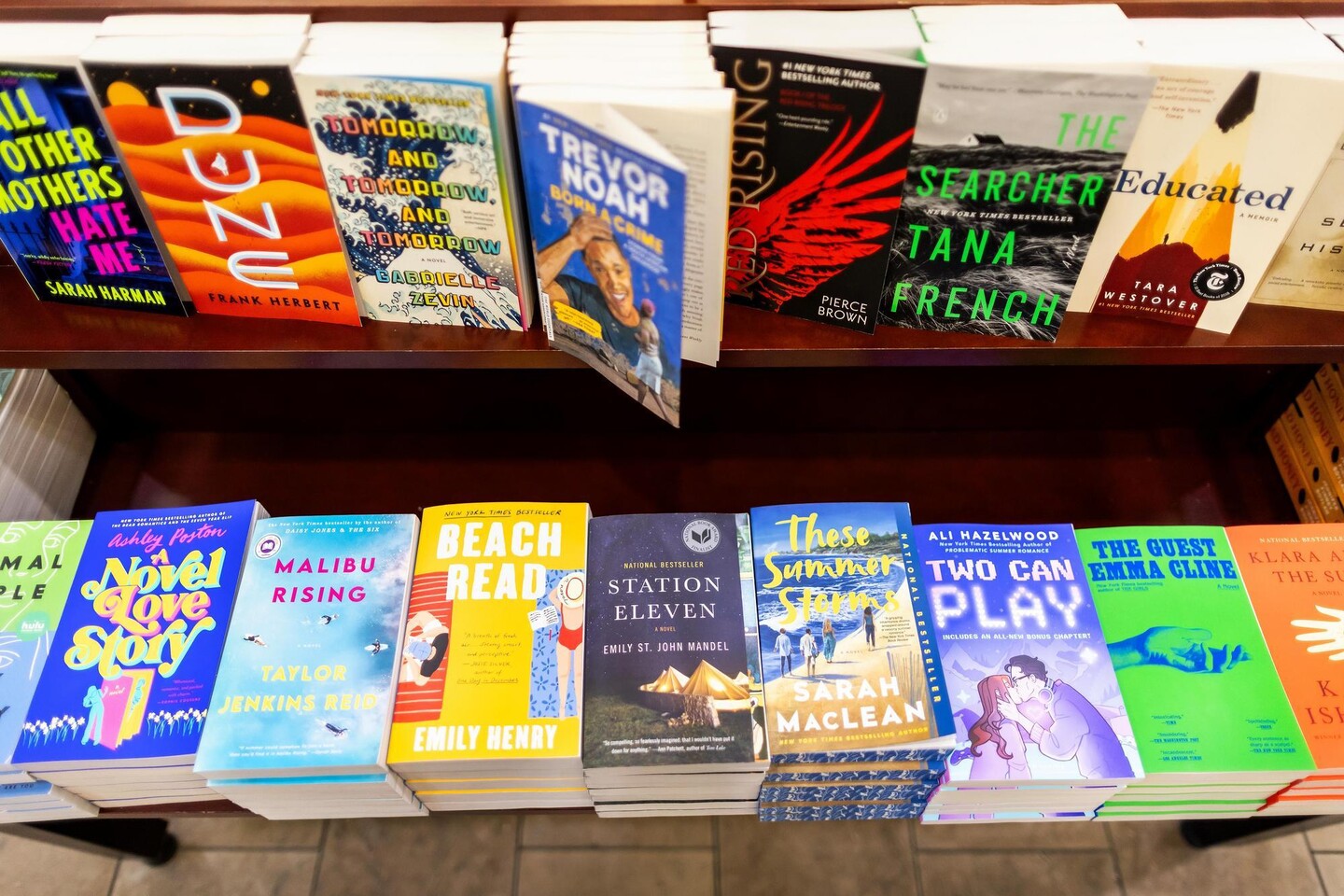 Seventeen books on display table in bookstore.