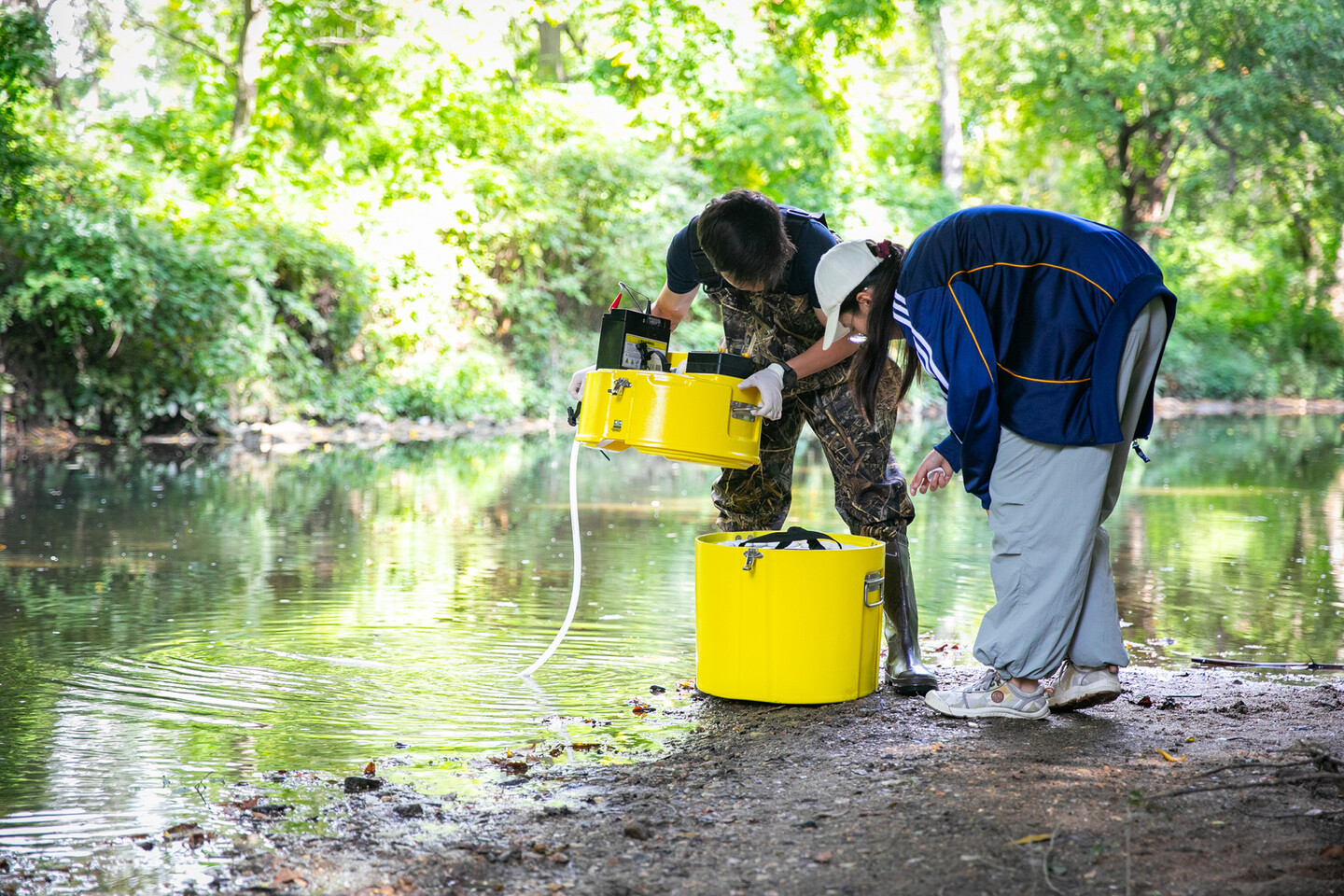Two students testing water quality at Cobbs Creek.