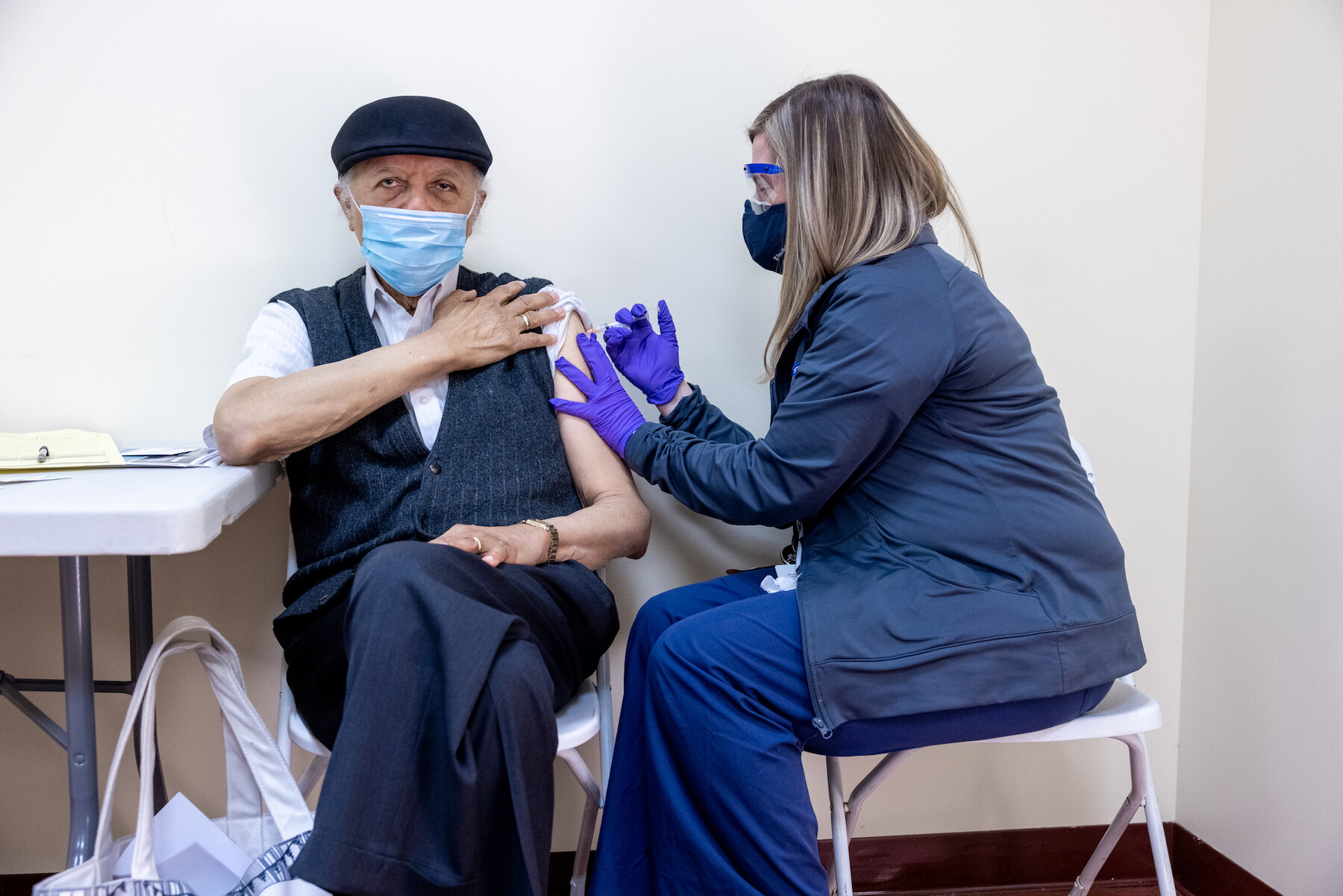 Person rolls up sleeve to receive a vaccination 