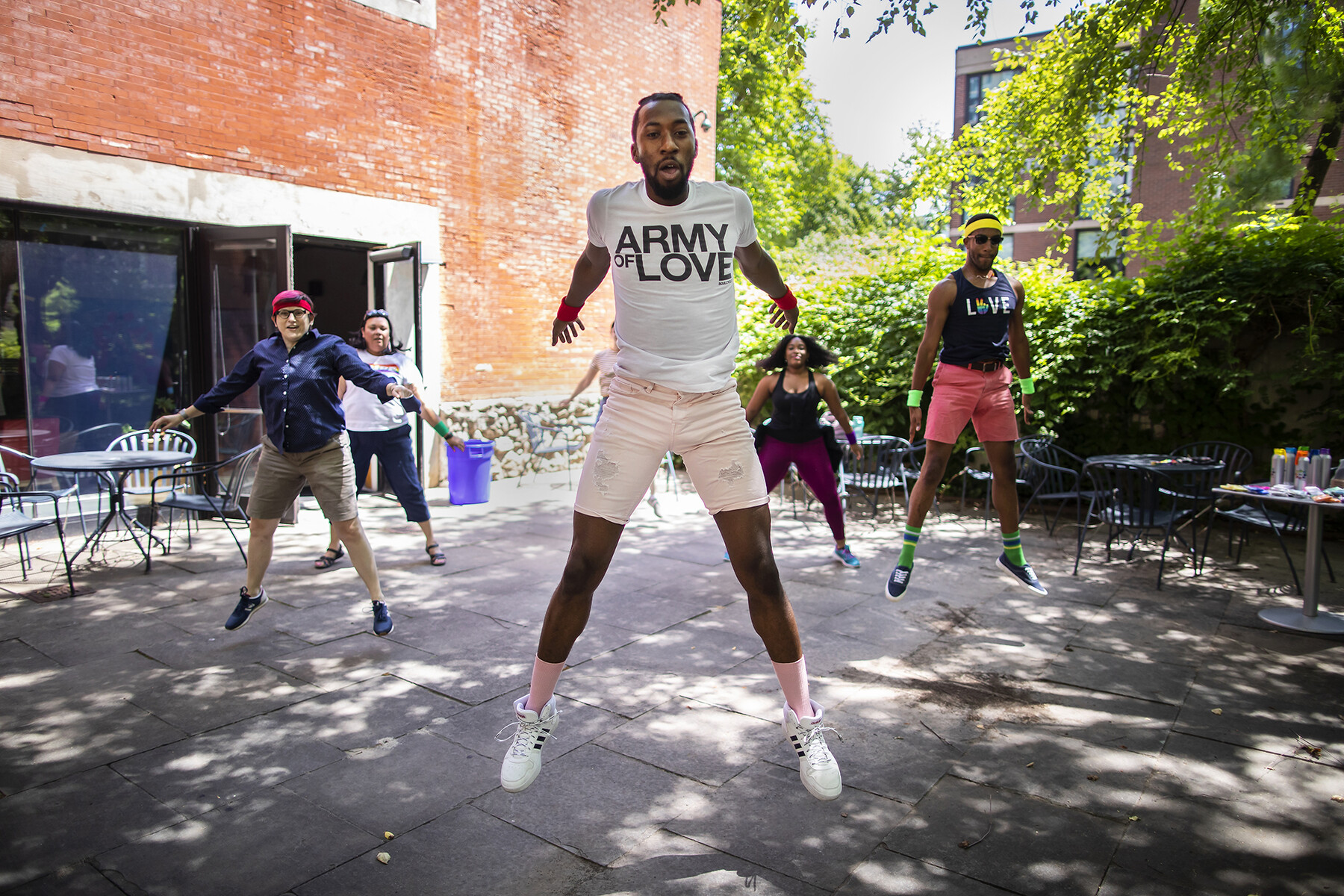 Five people jumping in mid-air in the courtyard on Penn’s campus.