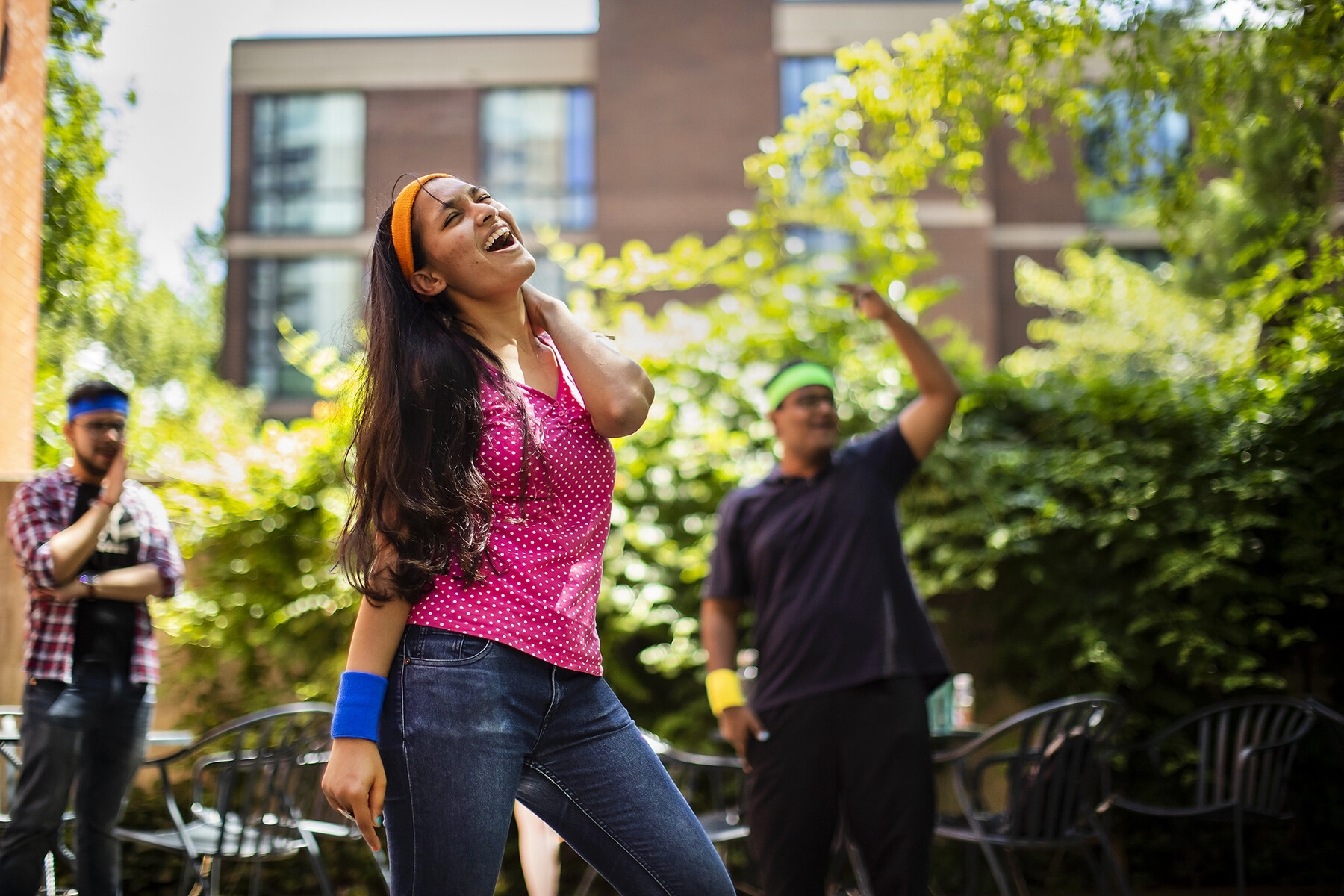Three people dancing outside in a courtyard on Penn’s campus.