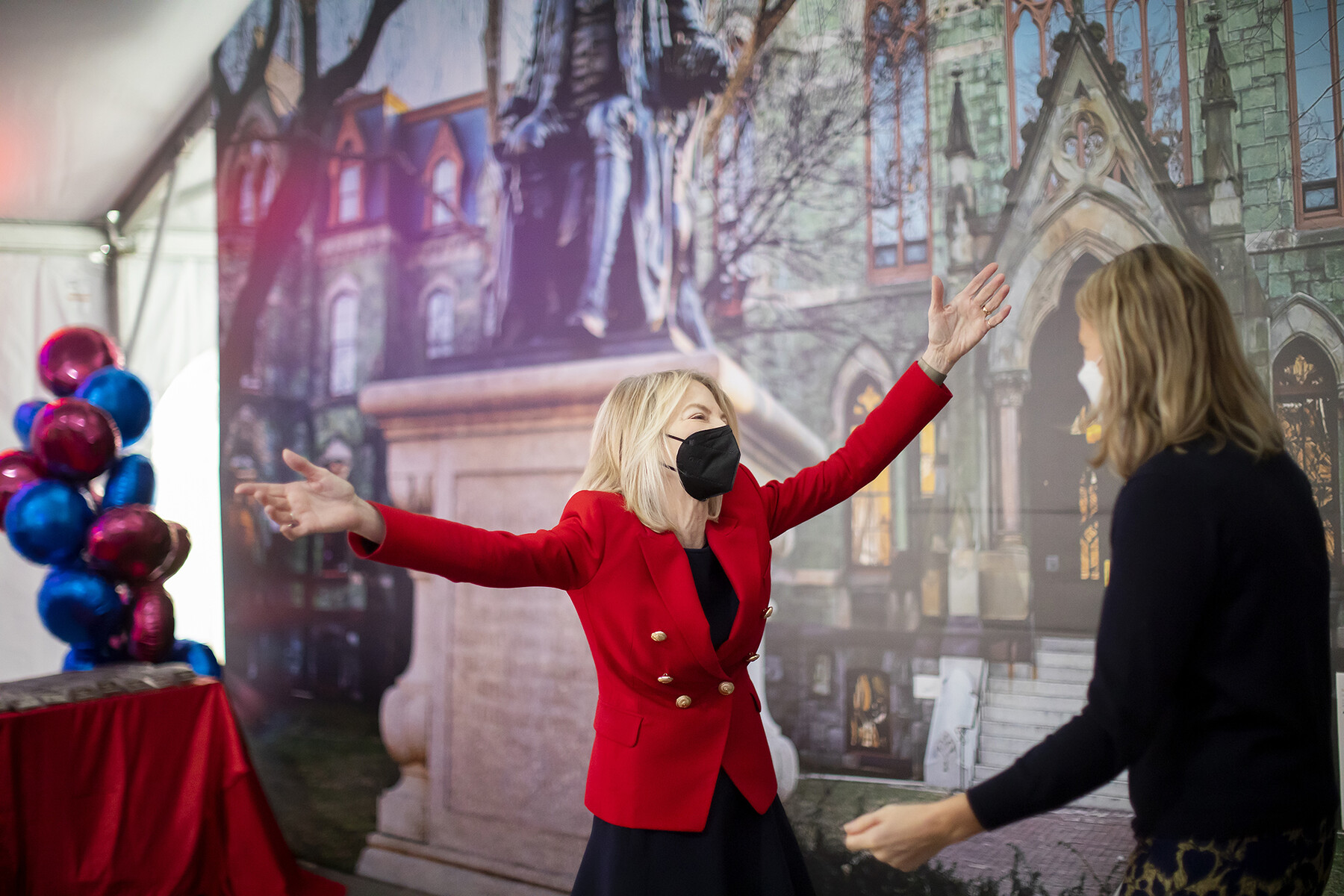 Penn President Amy Gutmann with arms open for a hug from someone.