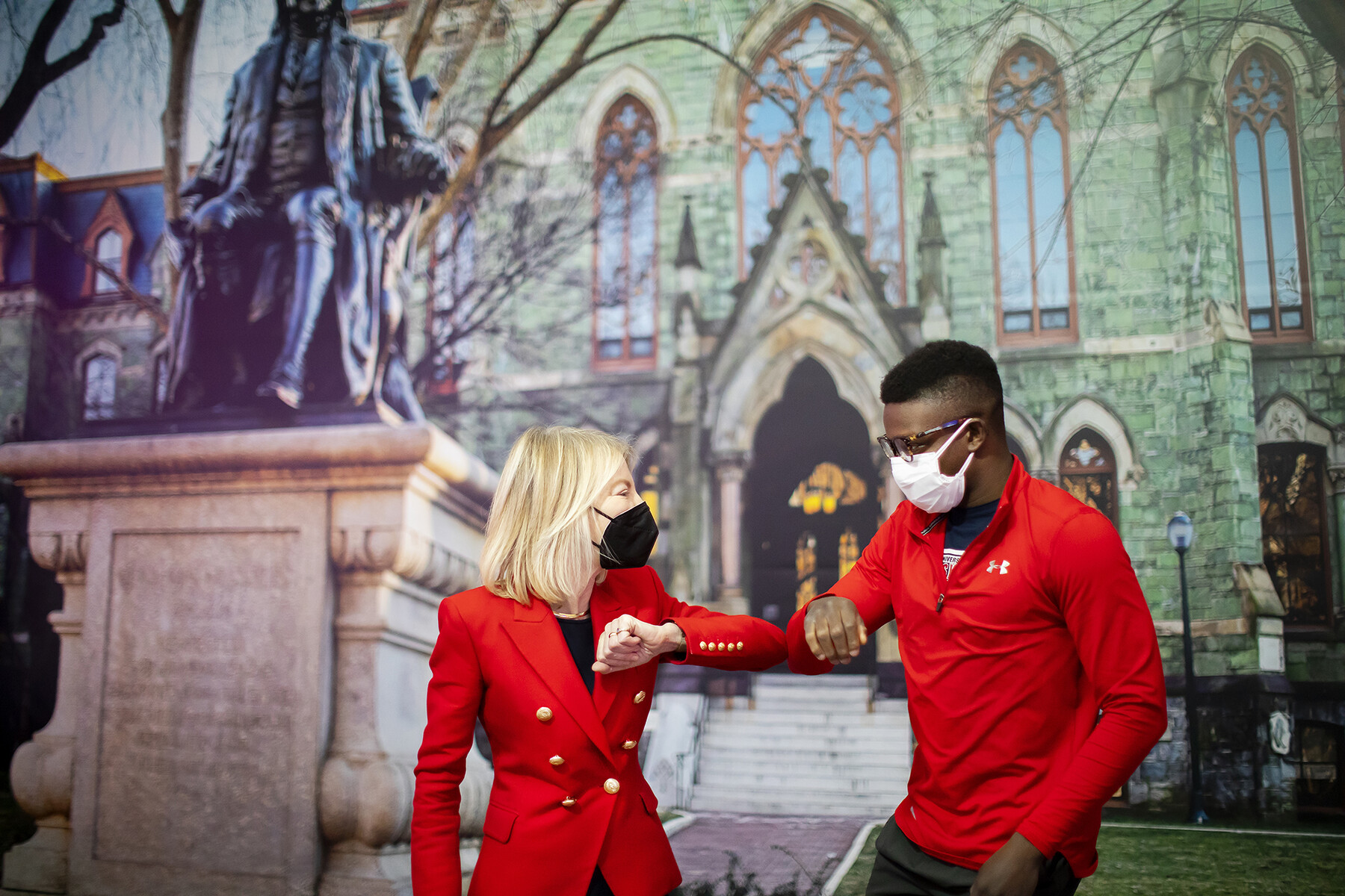 Penn President Amy Gutmann bumps elbows with a Penn student.