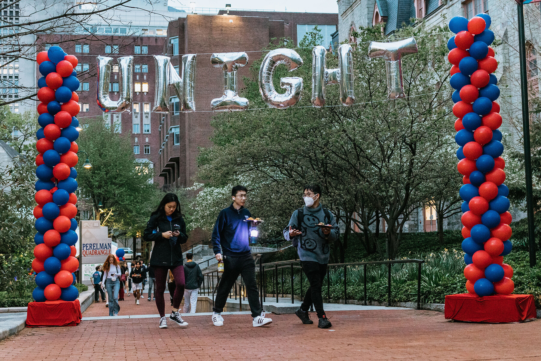 Three students walk under a display of balloons overhead which reads UNIGHT.