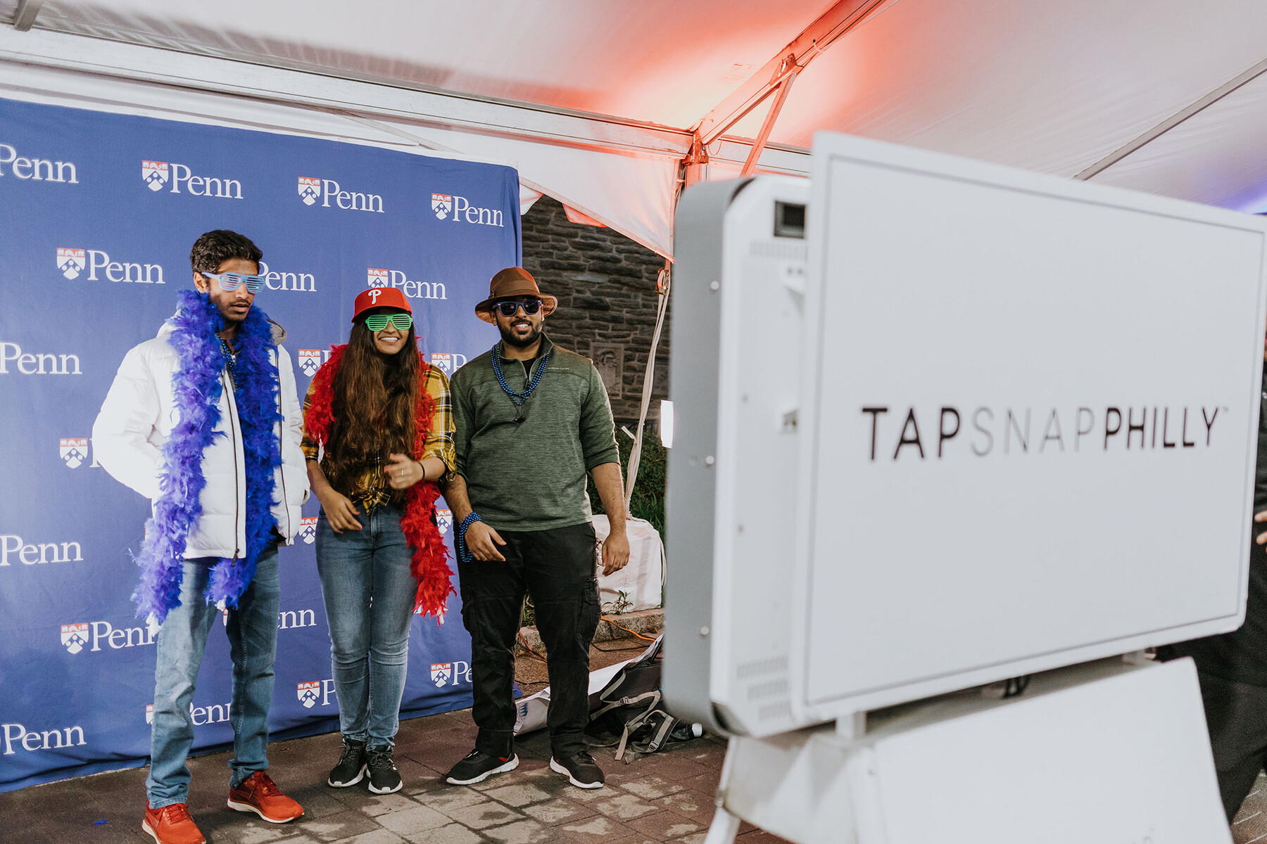 Three people have their photo taken in front of a Penn step-and-repeat.