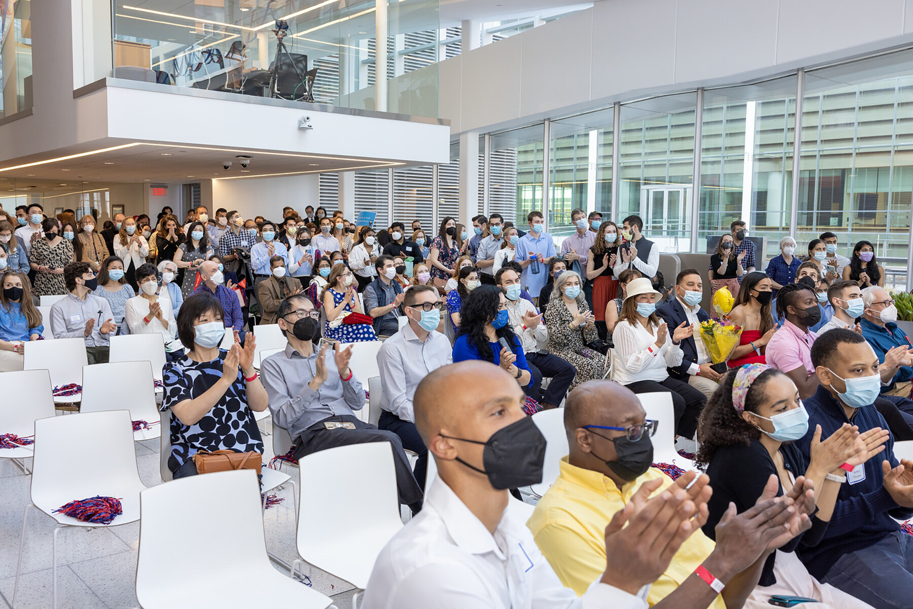 A seated crowd in the atrium at Penn Medicine claps for a speaker.