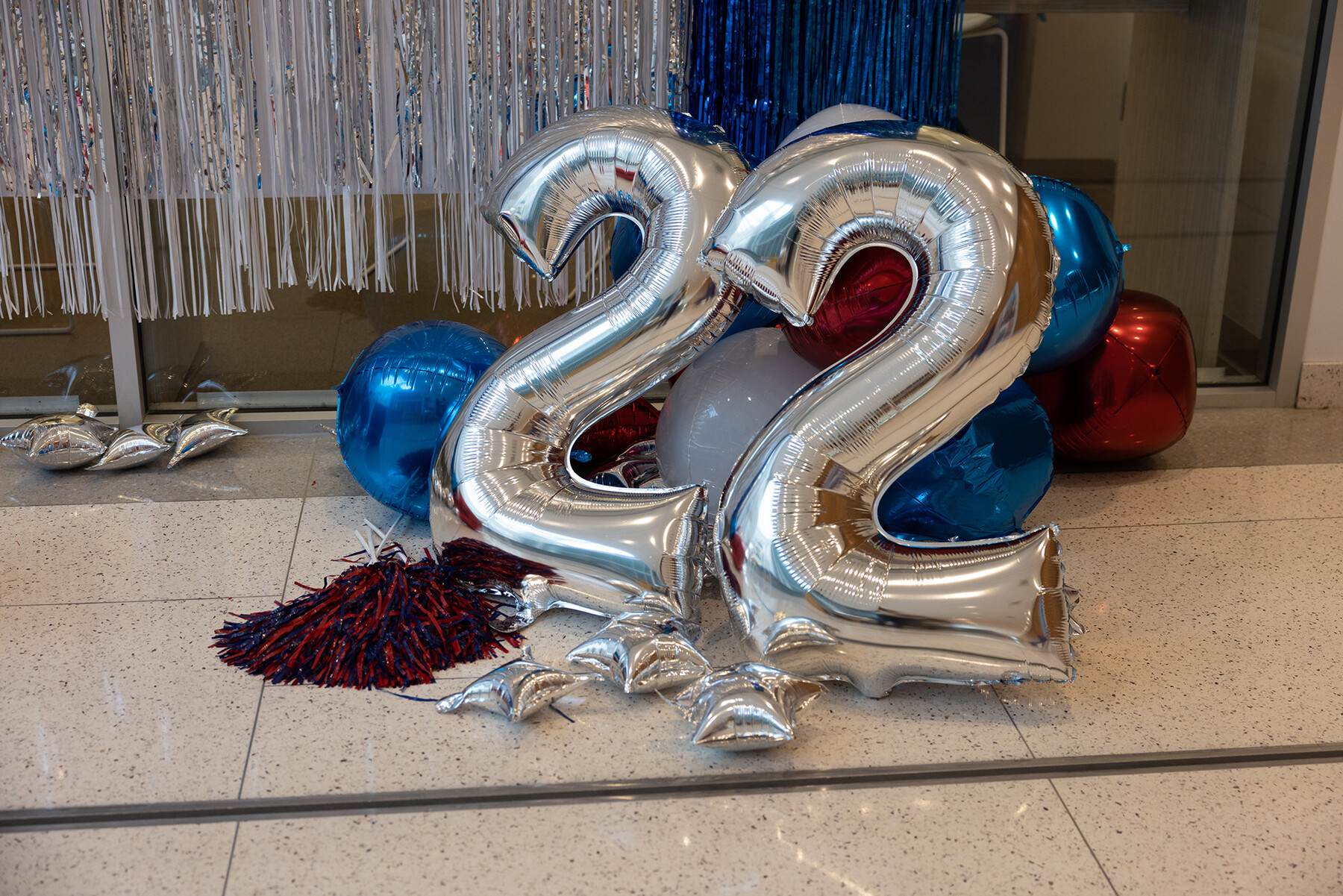 Red and blue balloons and two number 2 balloons on the ground.