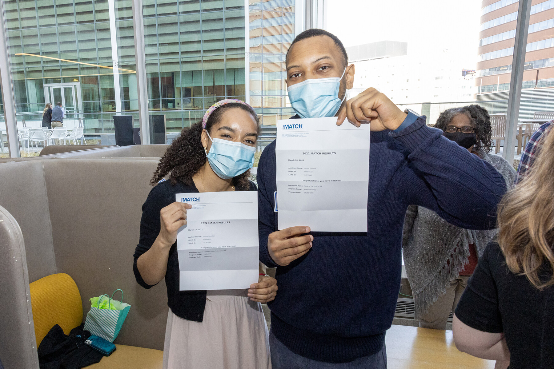 Two people hold up Match Day letters.