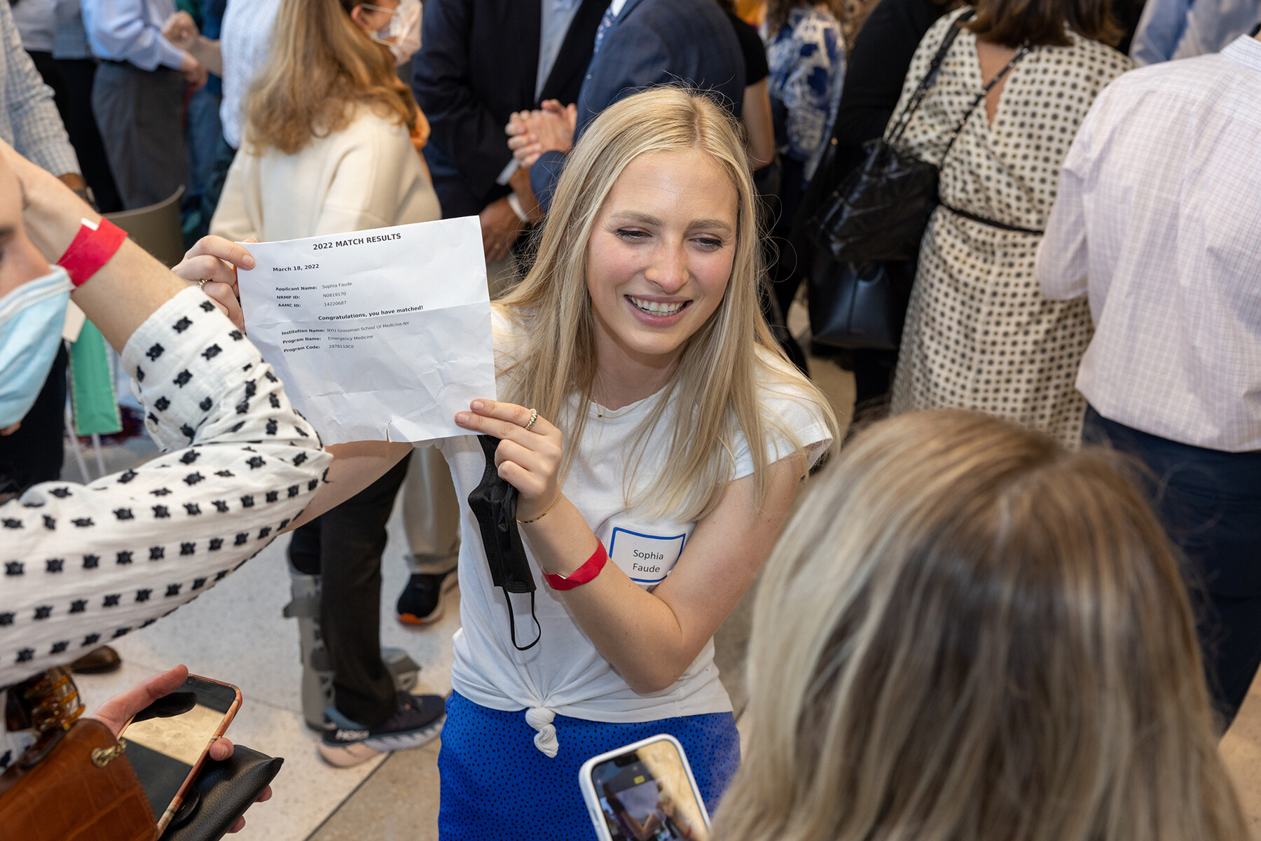 A Penn Med student smiles and holds up their Match Day letter.