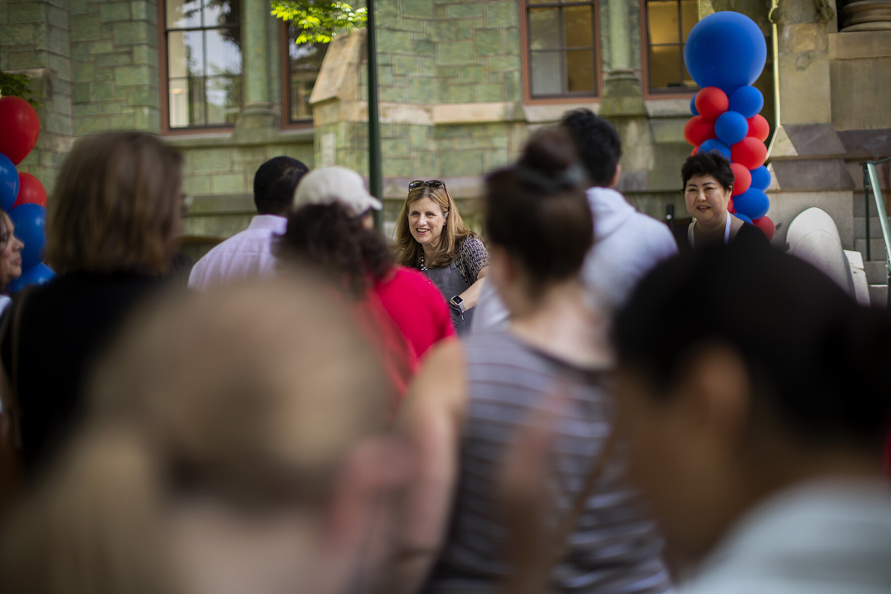 Liz Magill in front of College Hall with a crowd of people queueing.