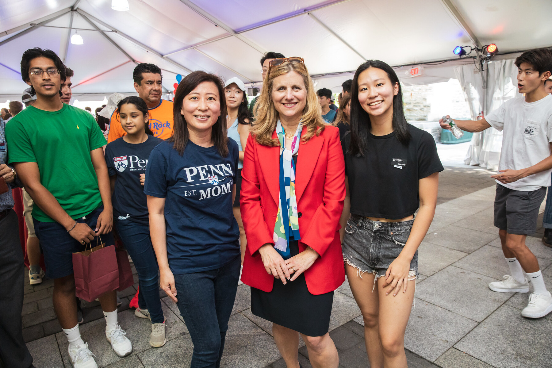 Penn President Liz Magill stands with a new student and their parent.