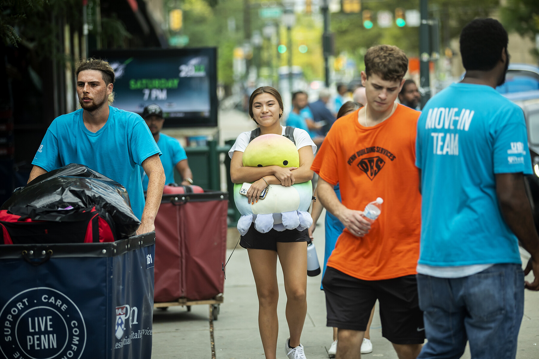 student walking down spruce street with stuffed animal