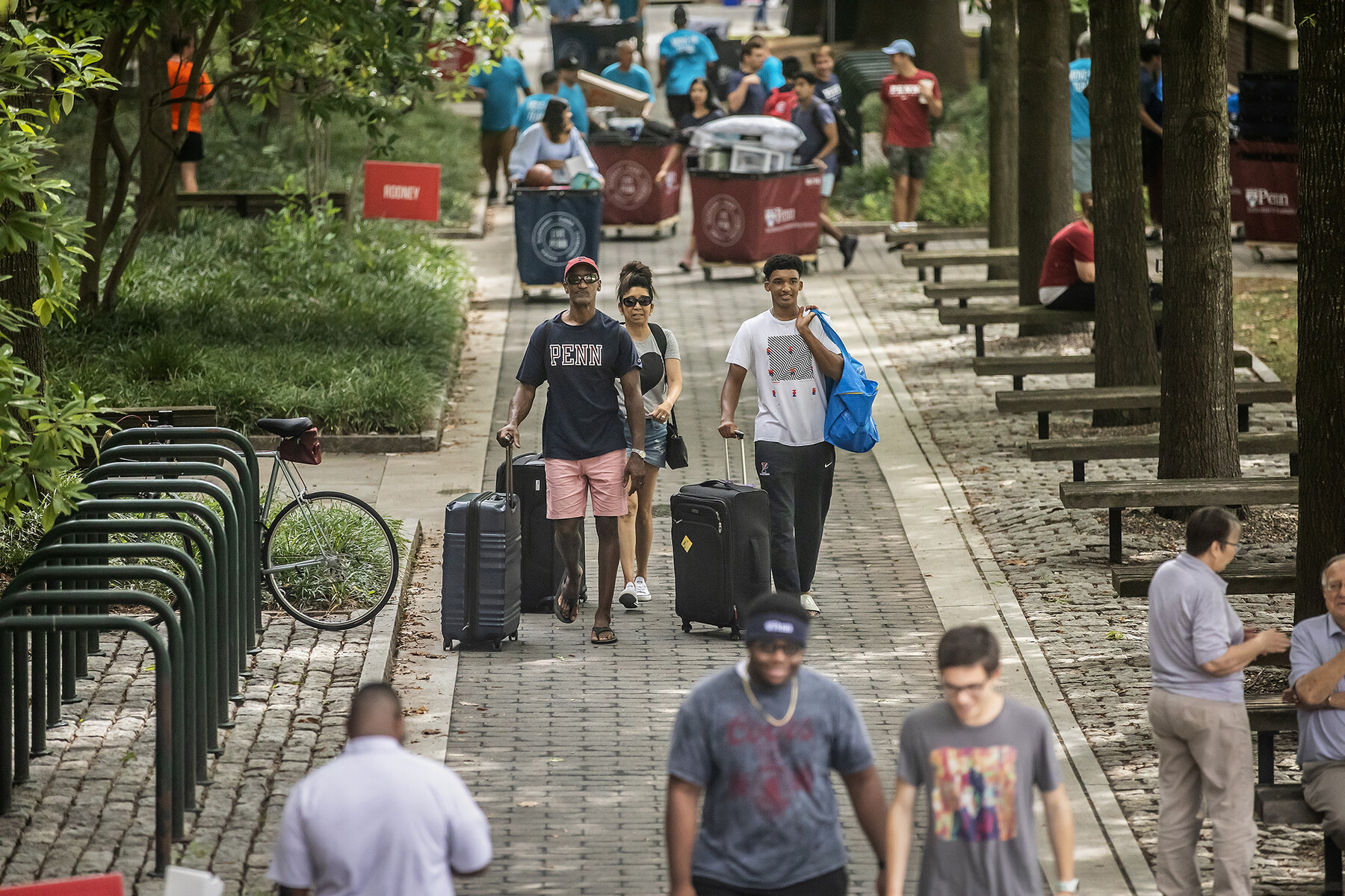 a penn family wheels suitcases through the quad