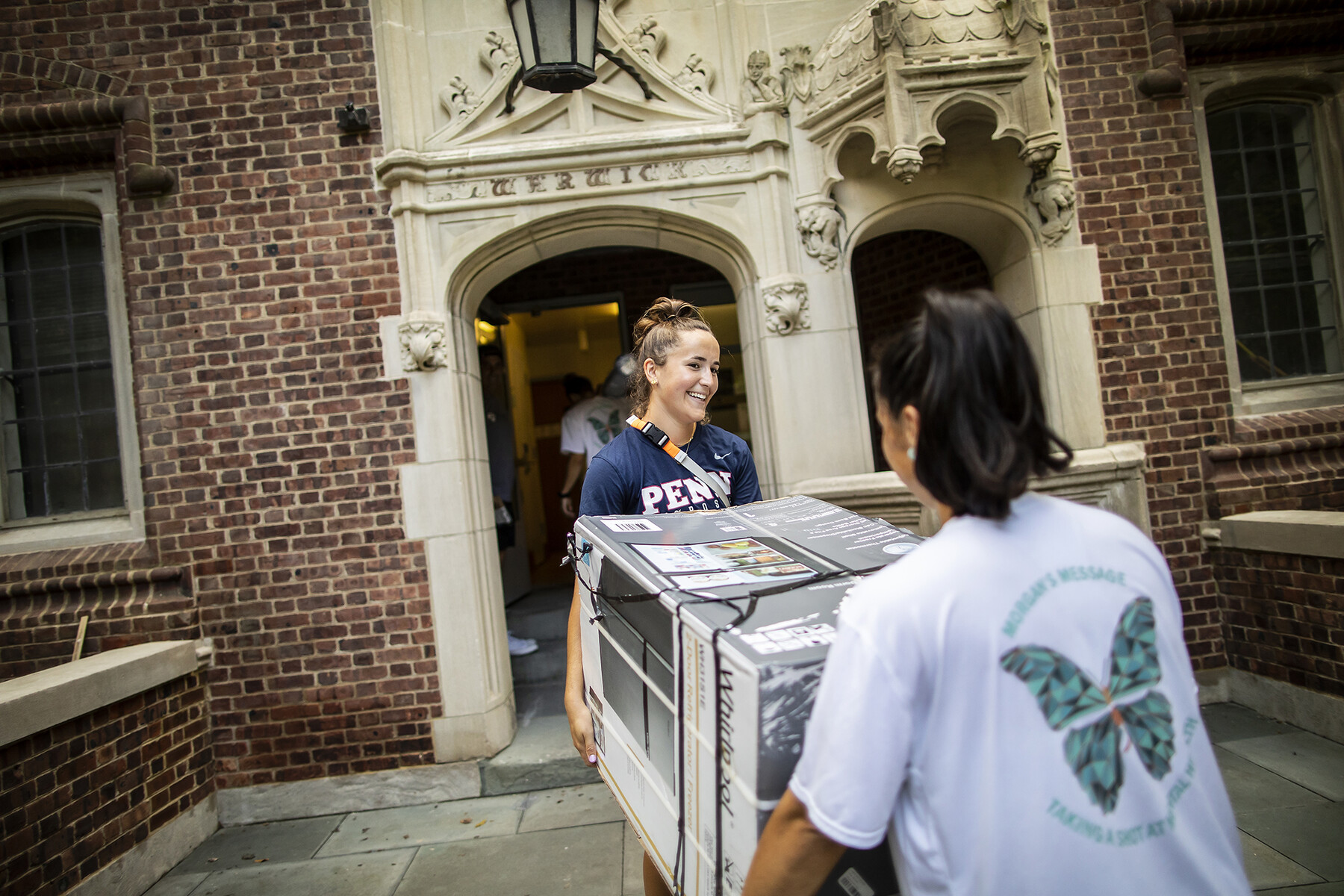student move a fridge into the quad