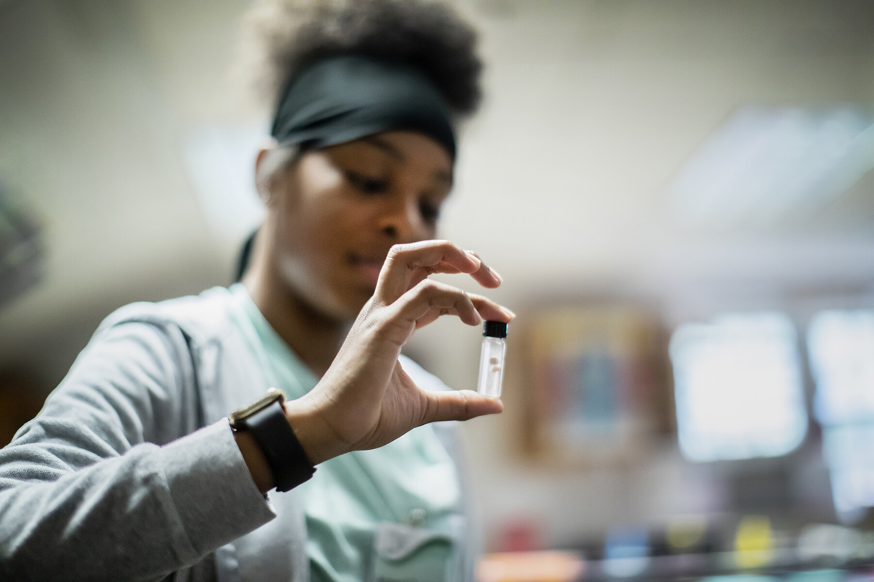 A student holds up a small vial.
