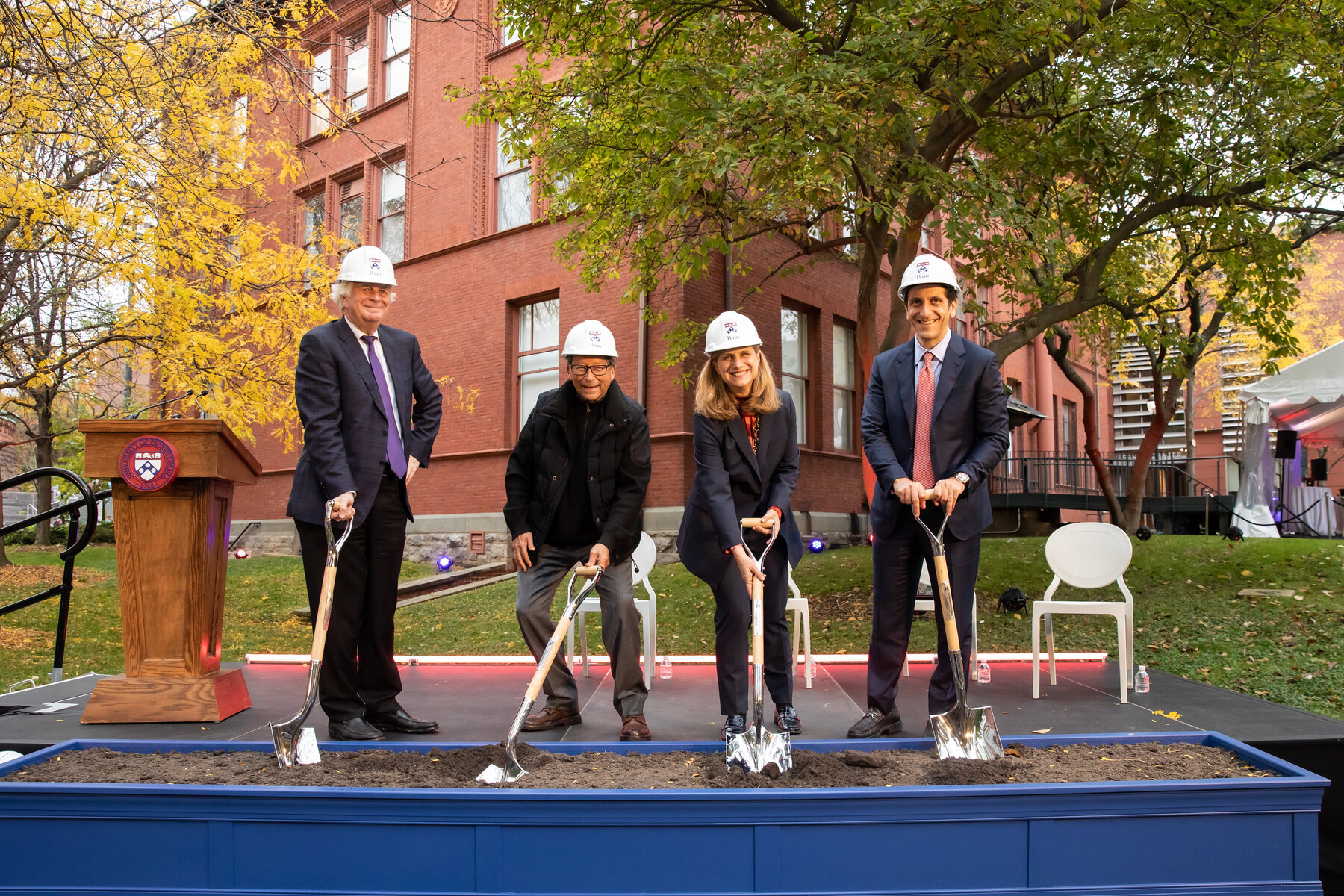 Liz Magill, Fritz Steiner, Stuart Weitzman and another wearing hard hats at a ceremonial groundbreaking at the Weitzman School.