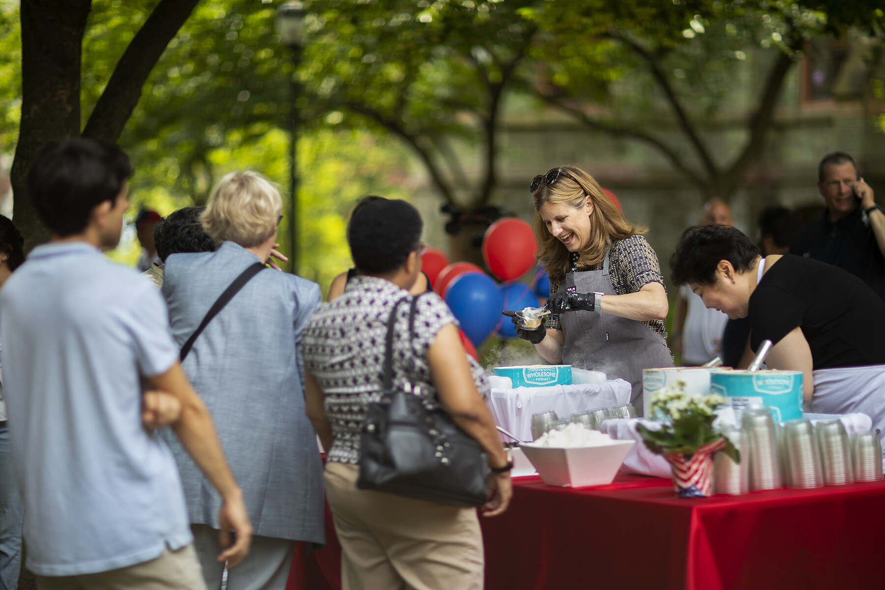 Liz Magill scoops ice cream for a crowd in front of College Hall.