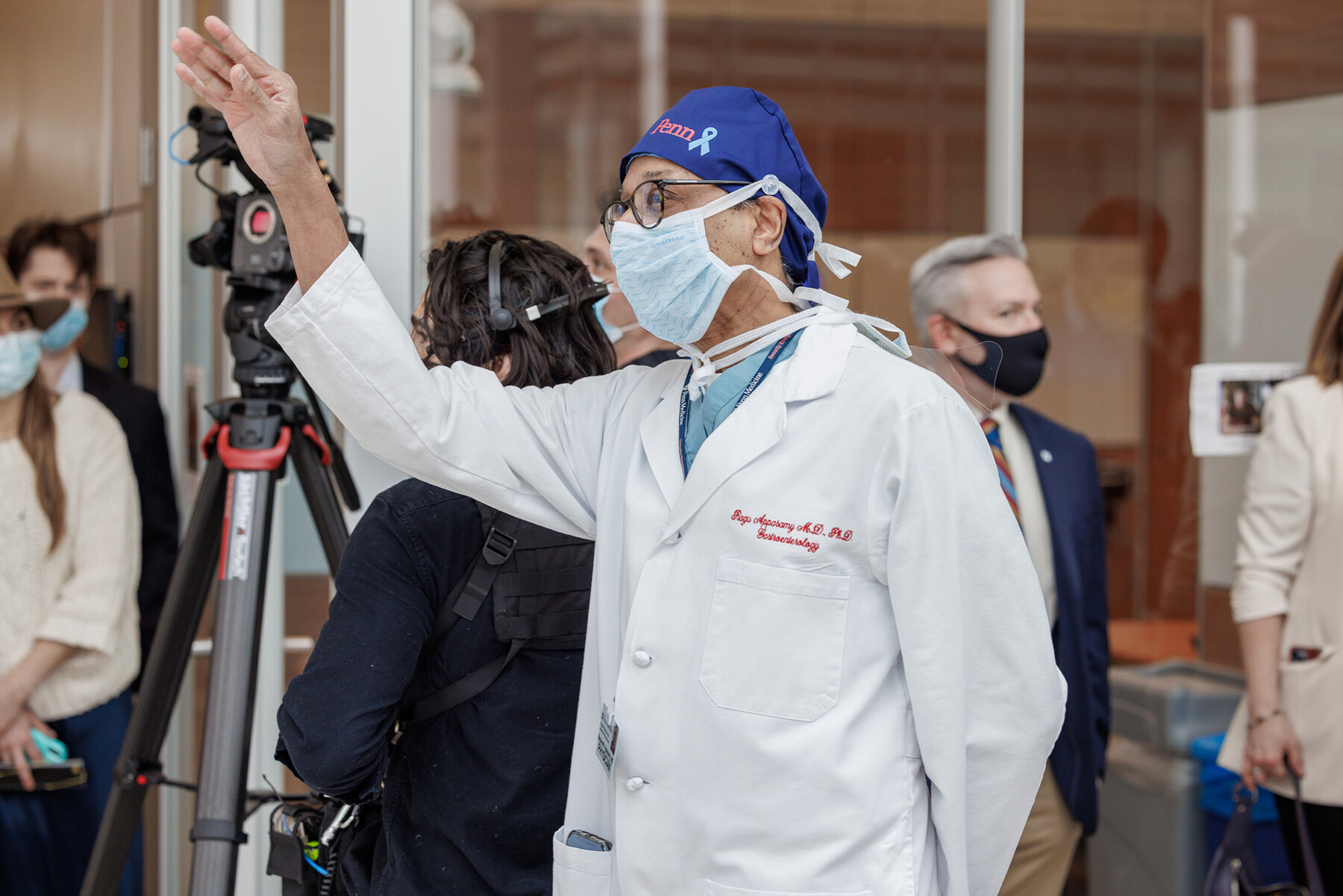 A doctor in a white coat waving at Penn Med Match Day.