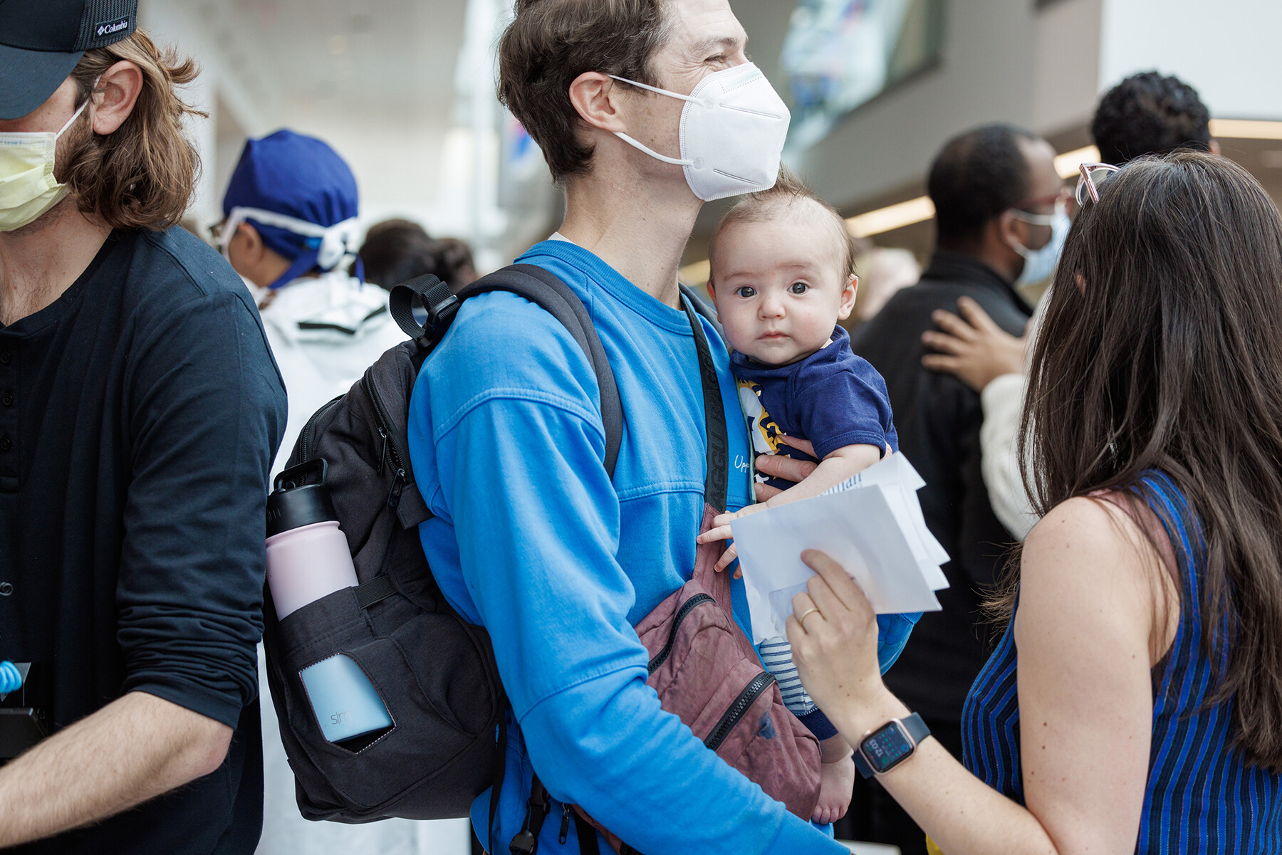 A person holding an infant in a crowd at Penn Med's Match Day.