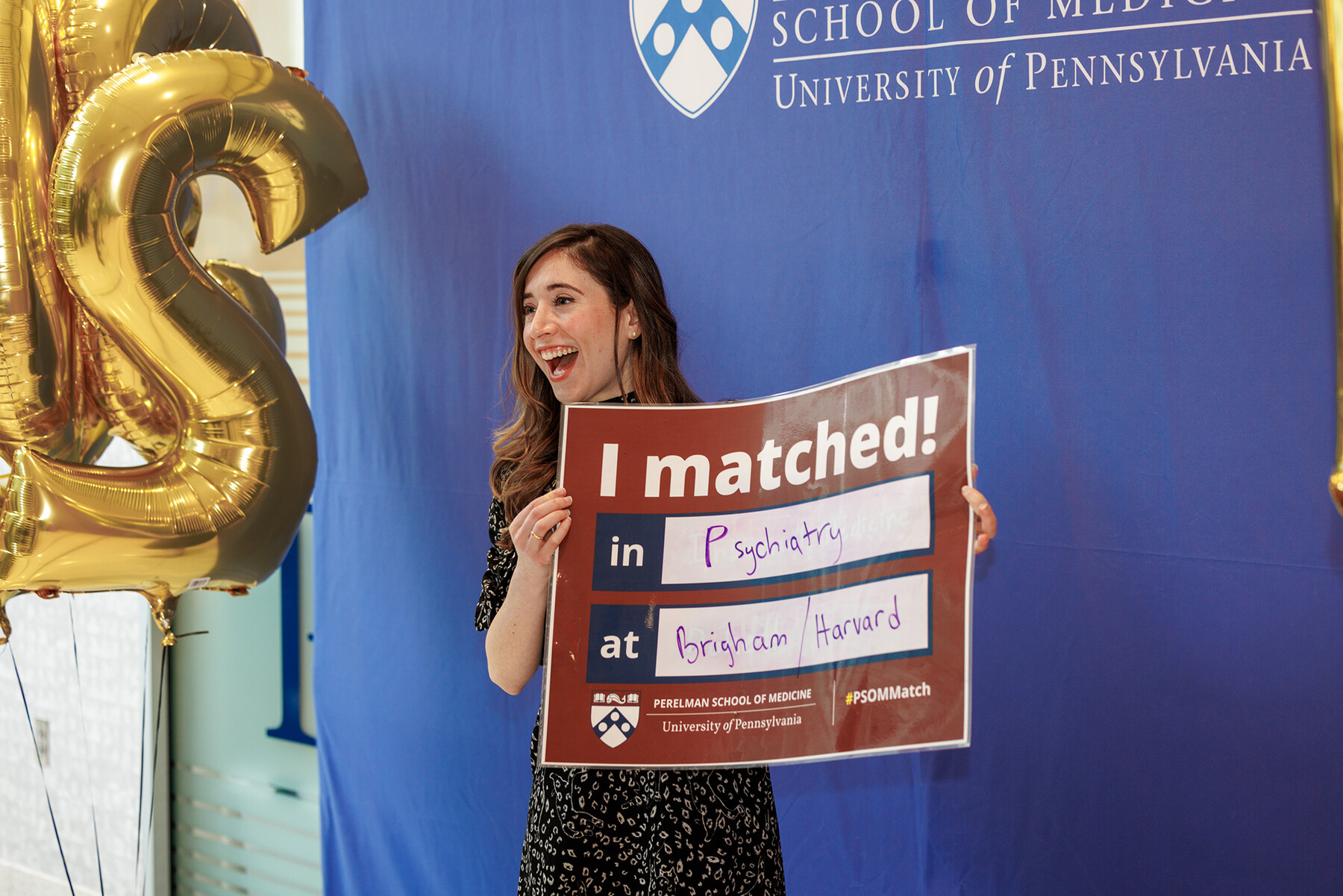 A person holding up a banner that reads I Matched!