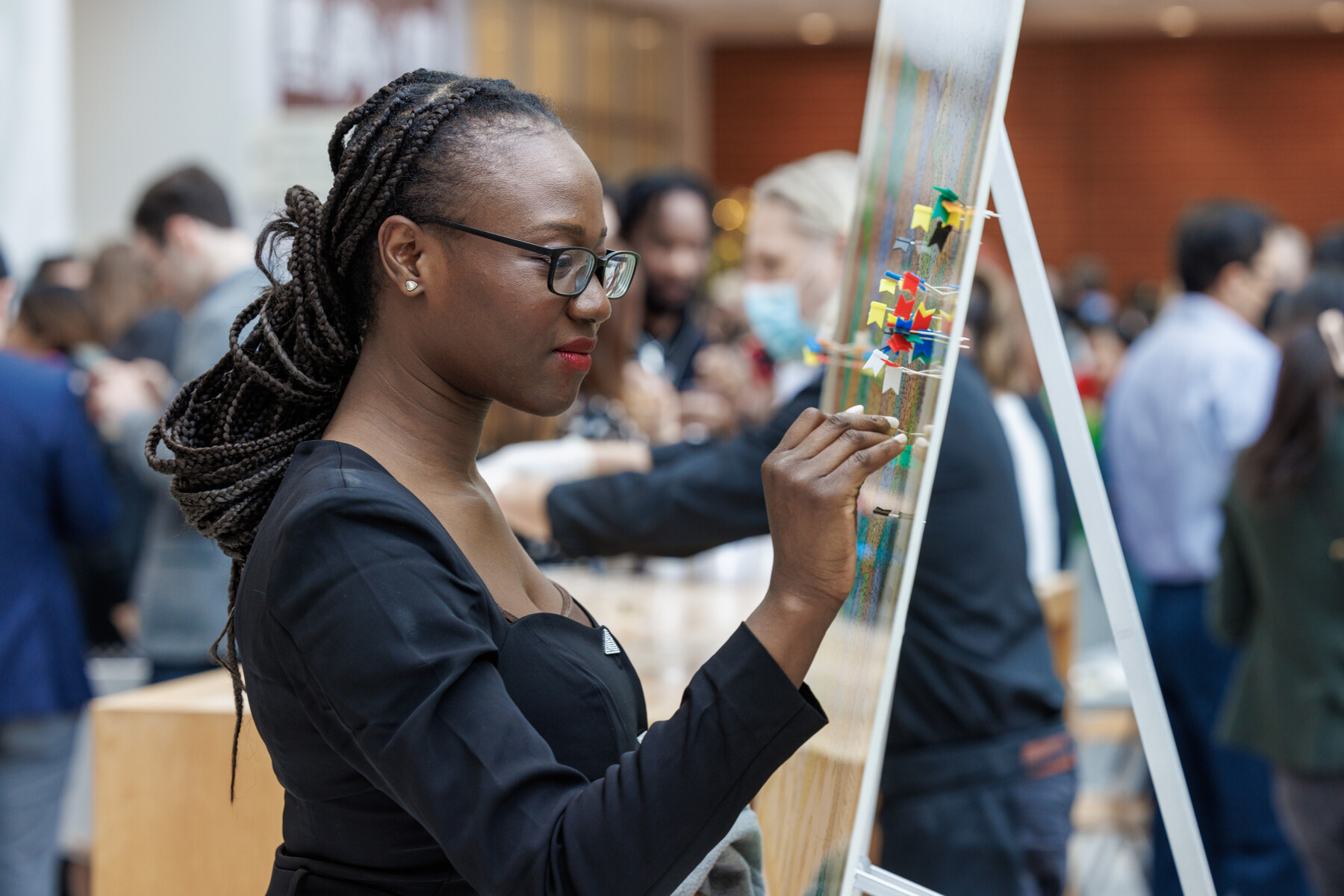 A person places a pin in the mounted map indicating where they will spend their medical residency.