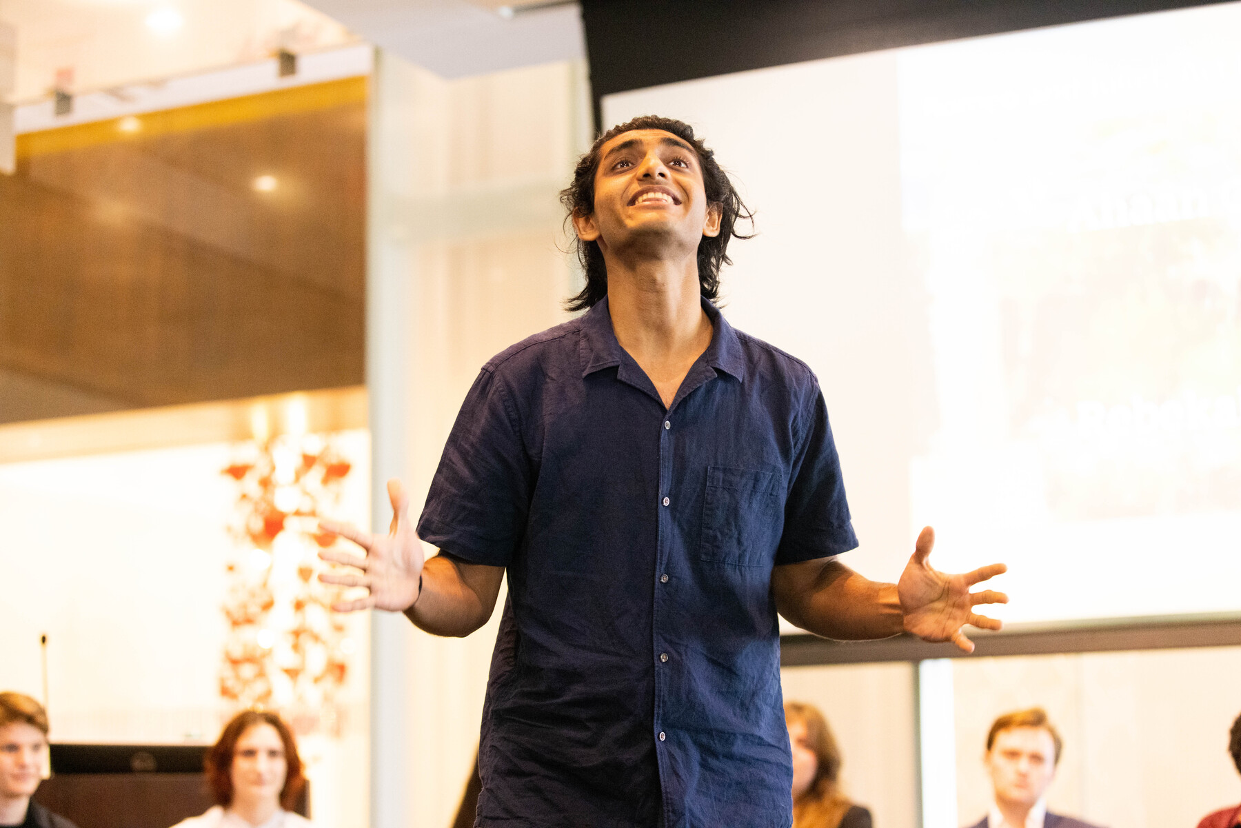 student standing with hands outstretched 