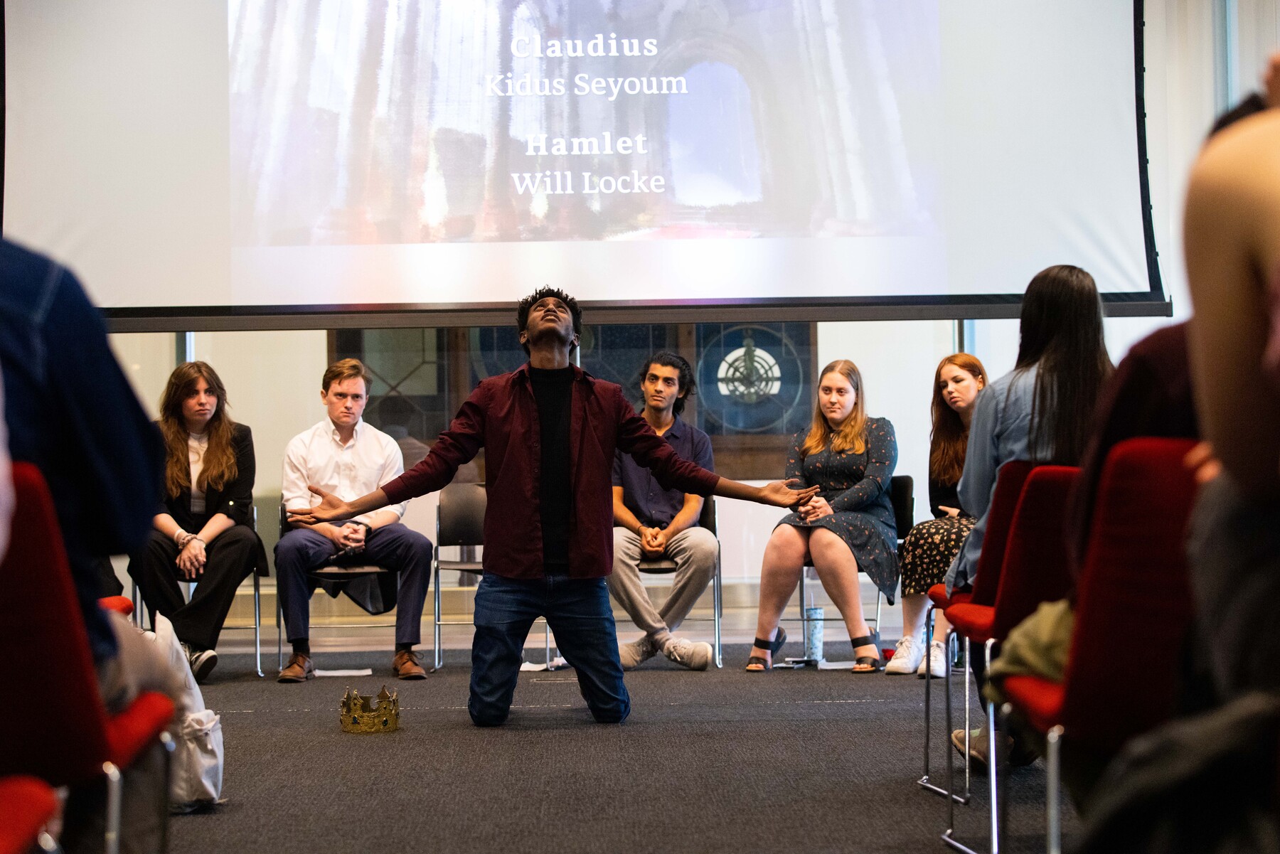 One student kneeling in front of audience