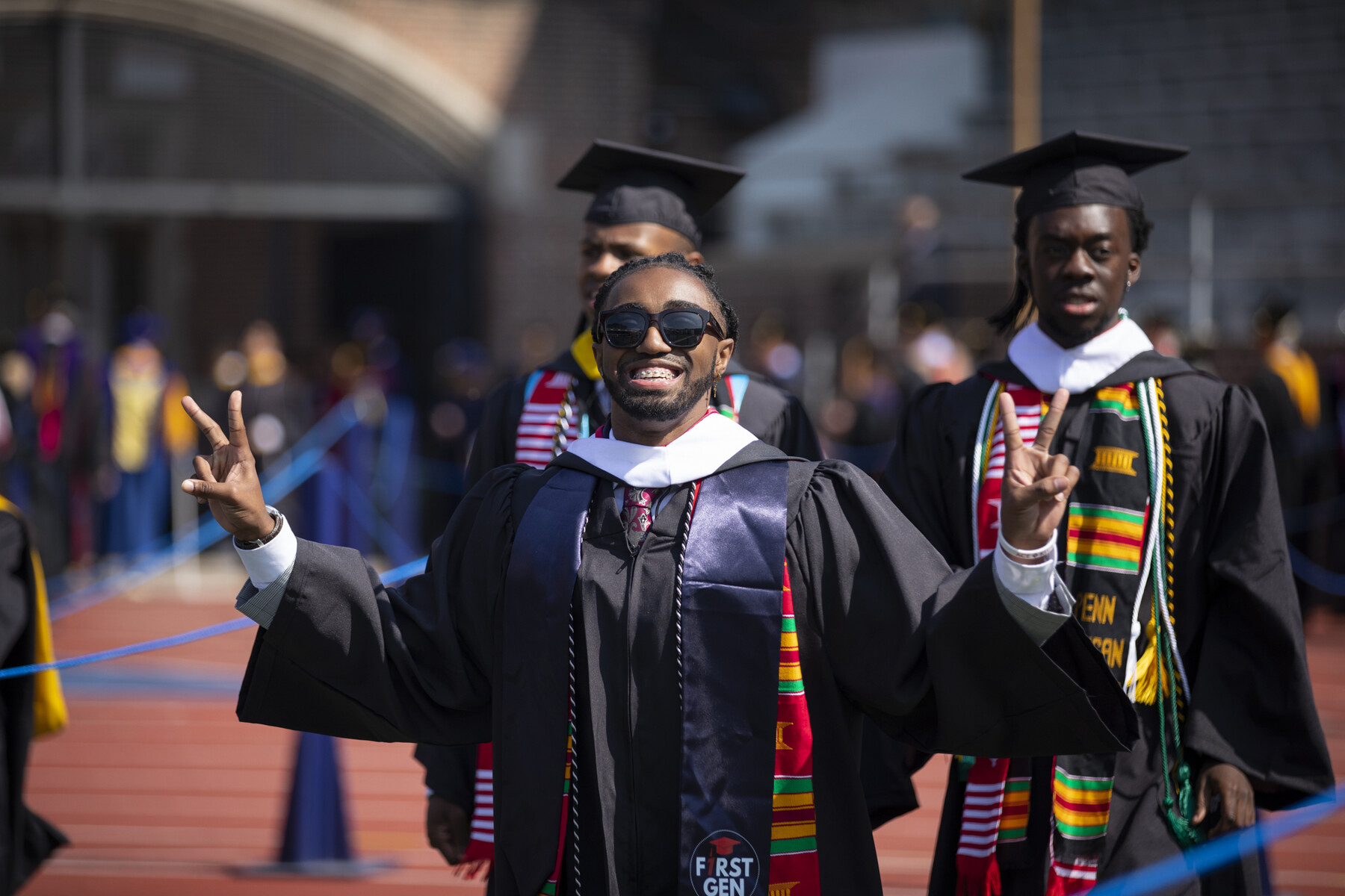 students enter franklin field, showing peace sign