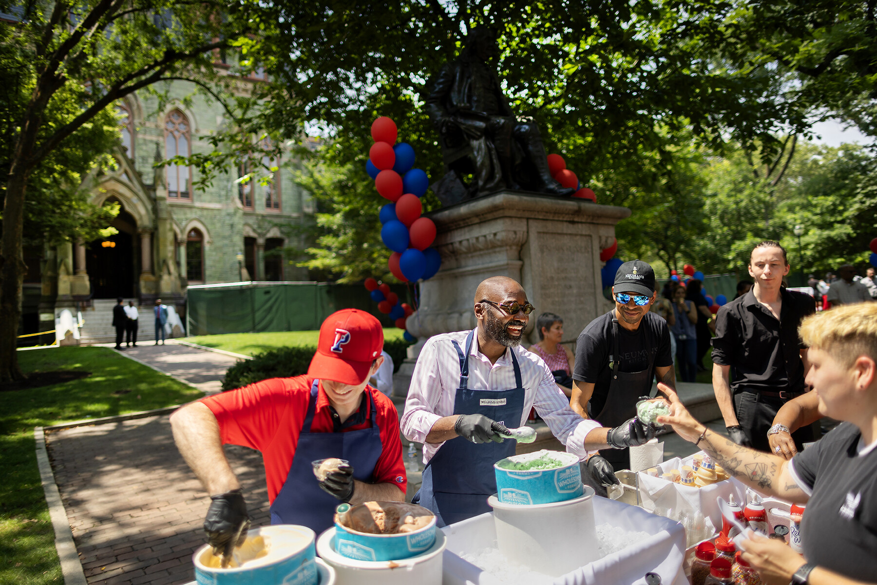 Liz Magill, John L. Jackson Jr. scoop ice cream in front of College Hall.