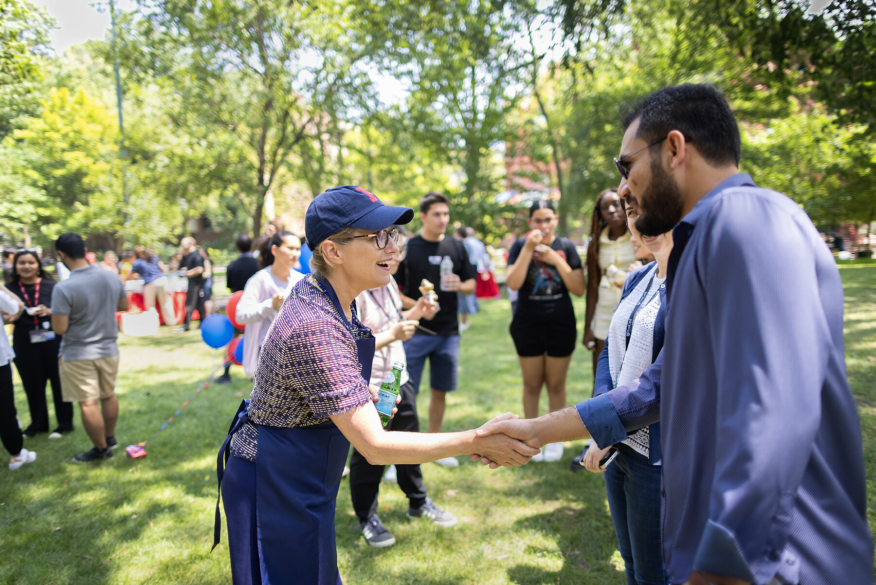 Liz Magill shakes hands with someone on College Green.