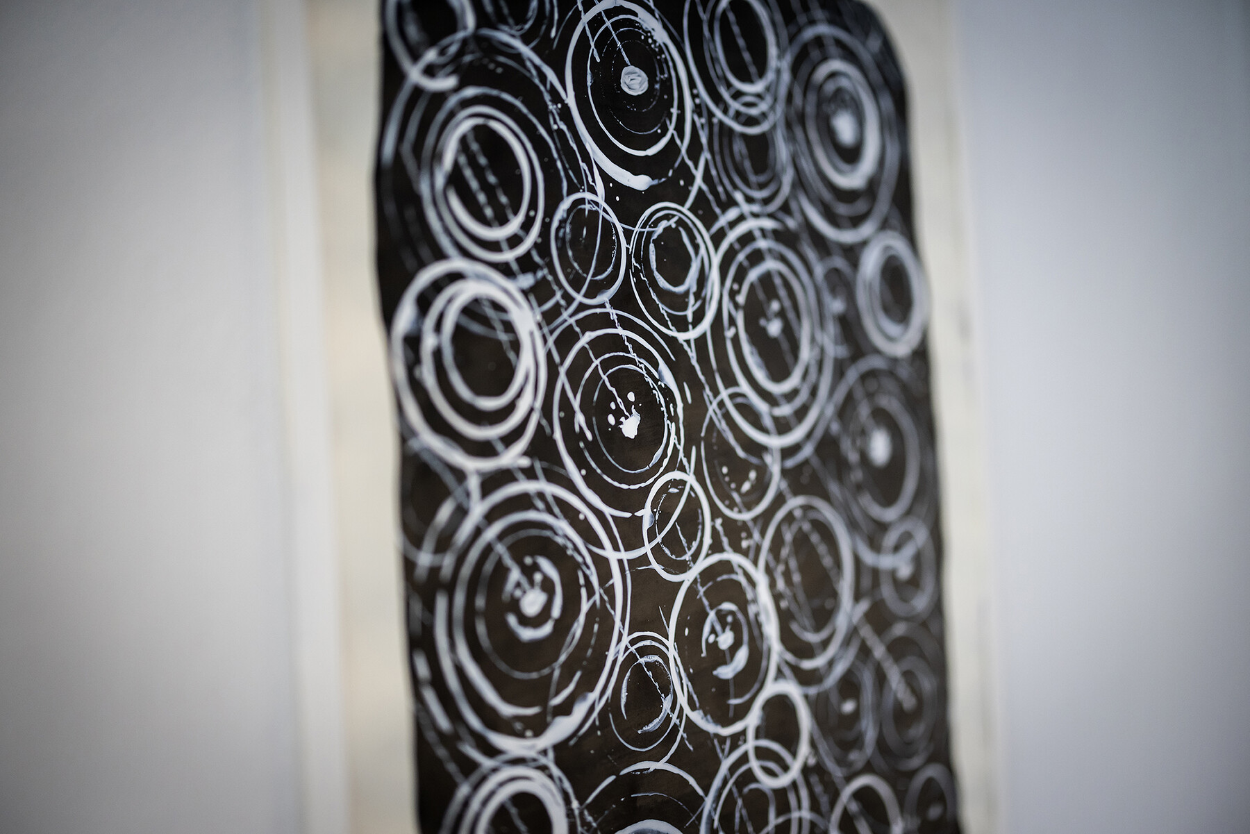 artwork with light concentric circles on dark background