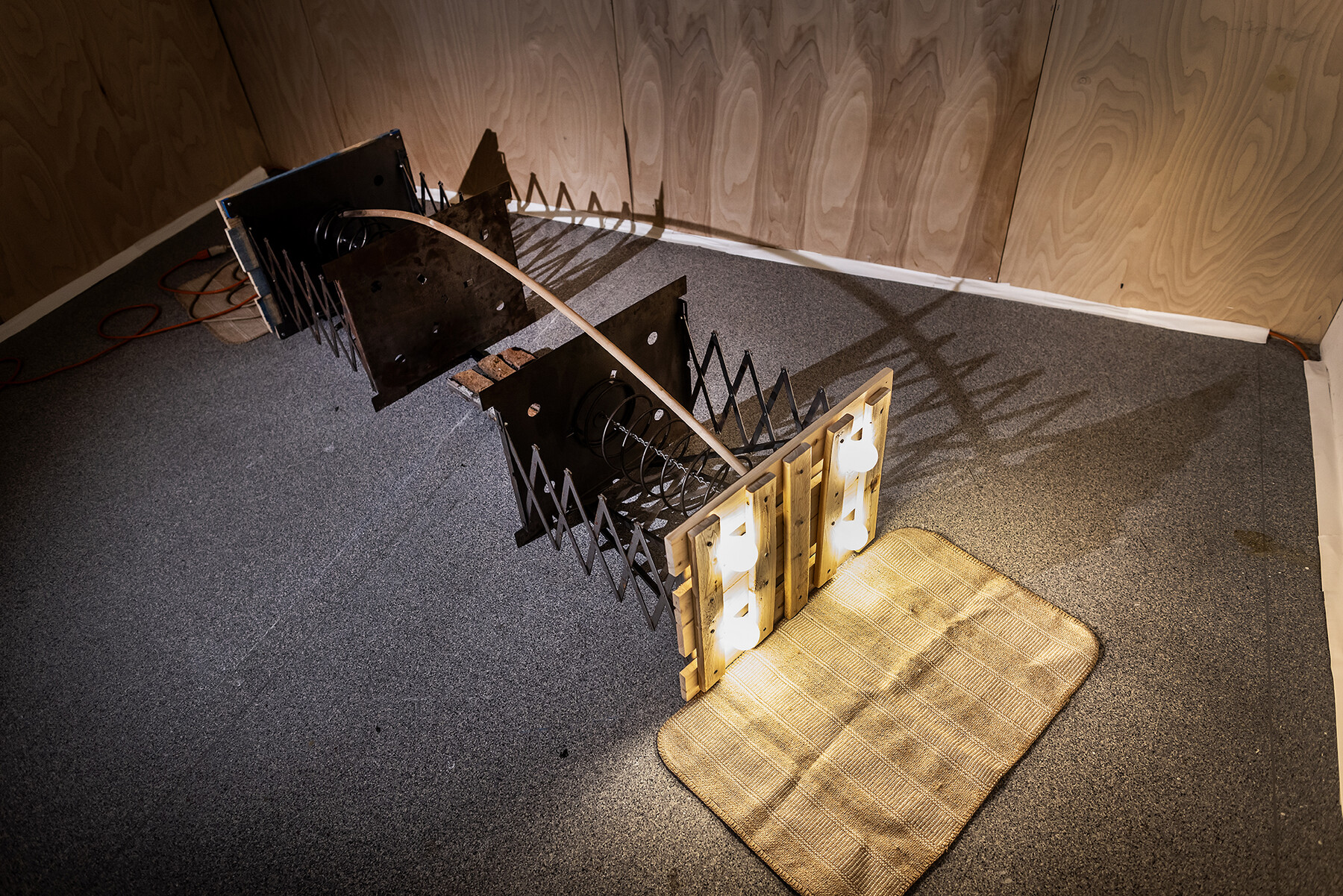 artwork on the floor with found objects put together including steel, brick, and wood