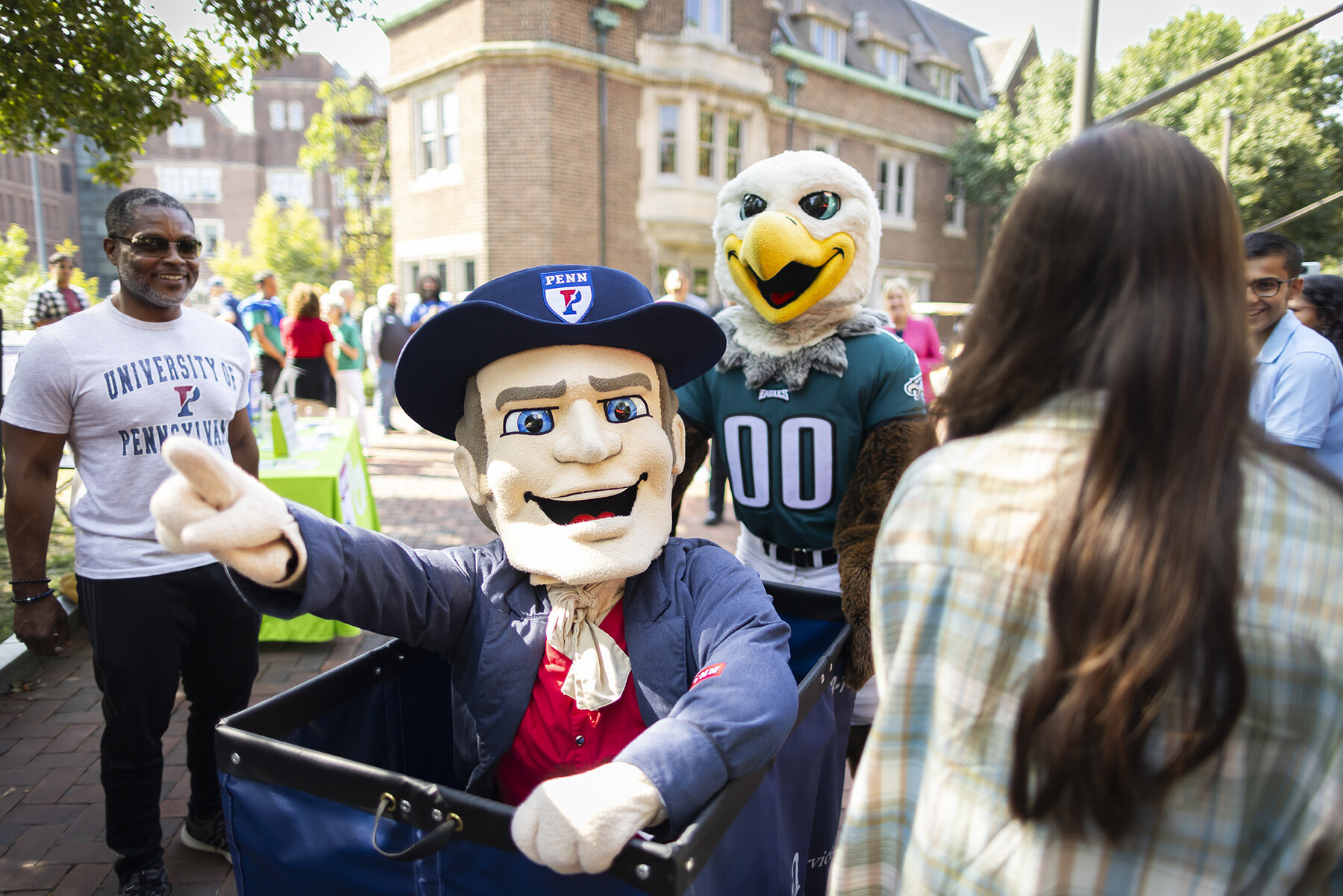 The Penn Quaker is pushed in a Move-In bin by the Philadelphia Eagles mascot.