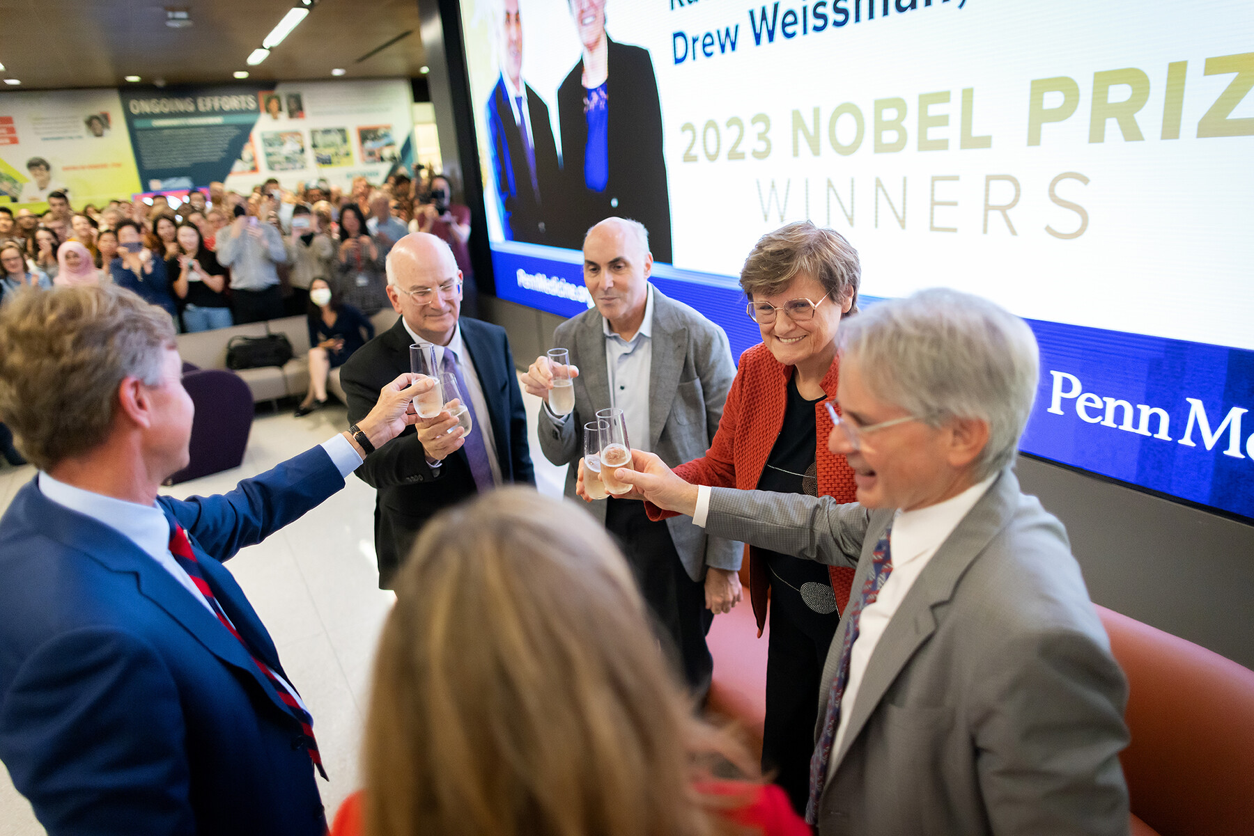 Katalin Kariko and Drew Weissman toast J. Larry Jameson and three others with champagne at the flash mob.