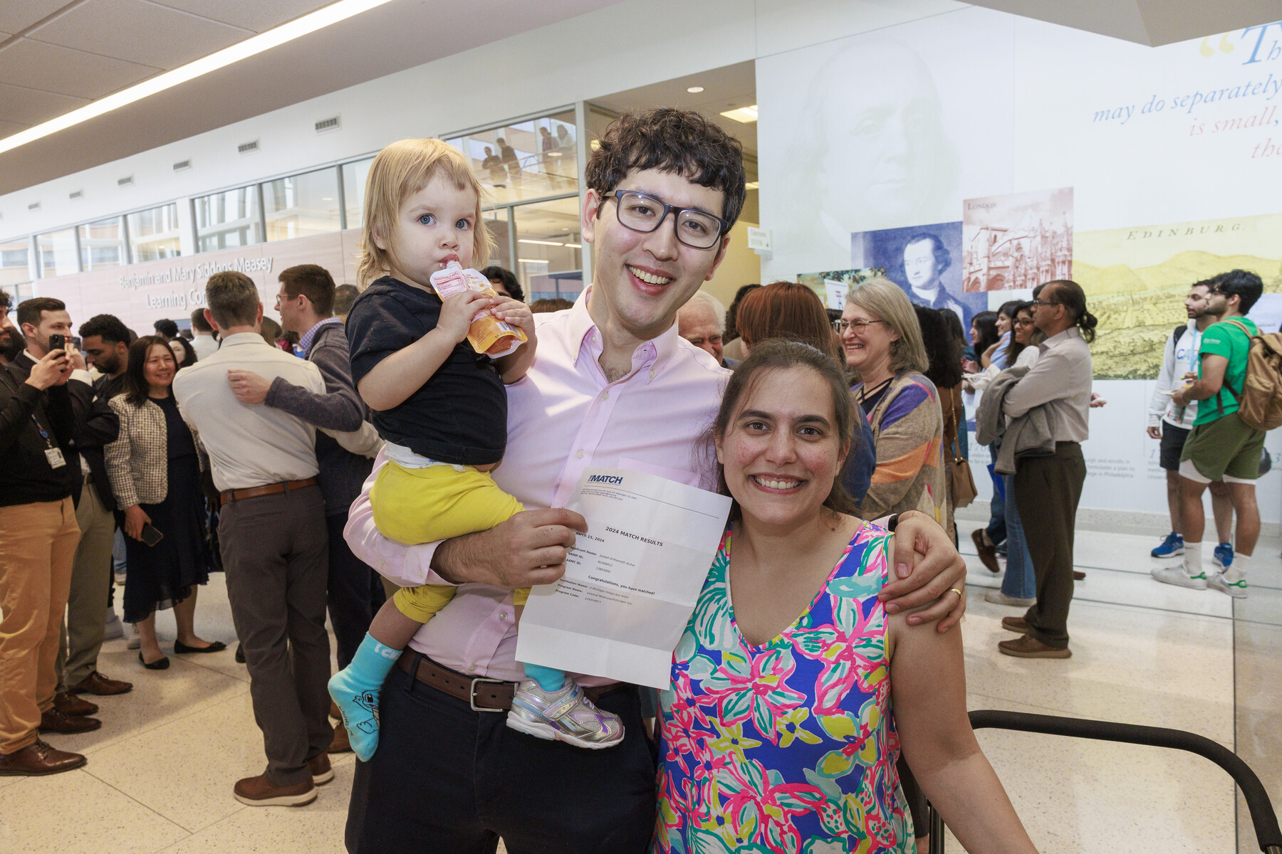 A student with their spouse and baby at Penn’s Match Day 2024.