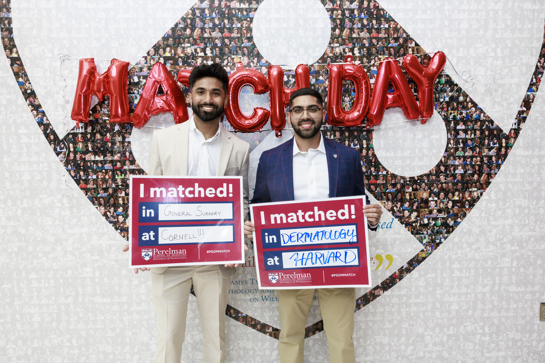 Two students holding Match Day signs in front of Match Day balloons.