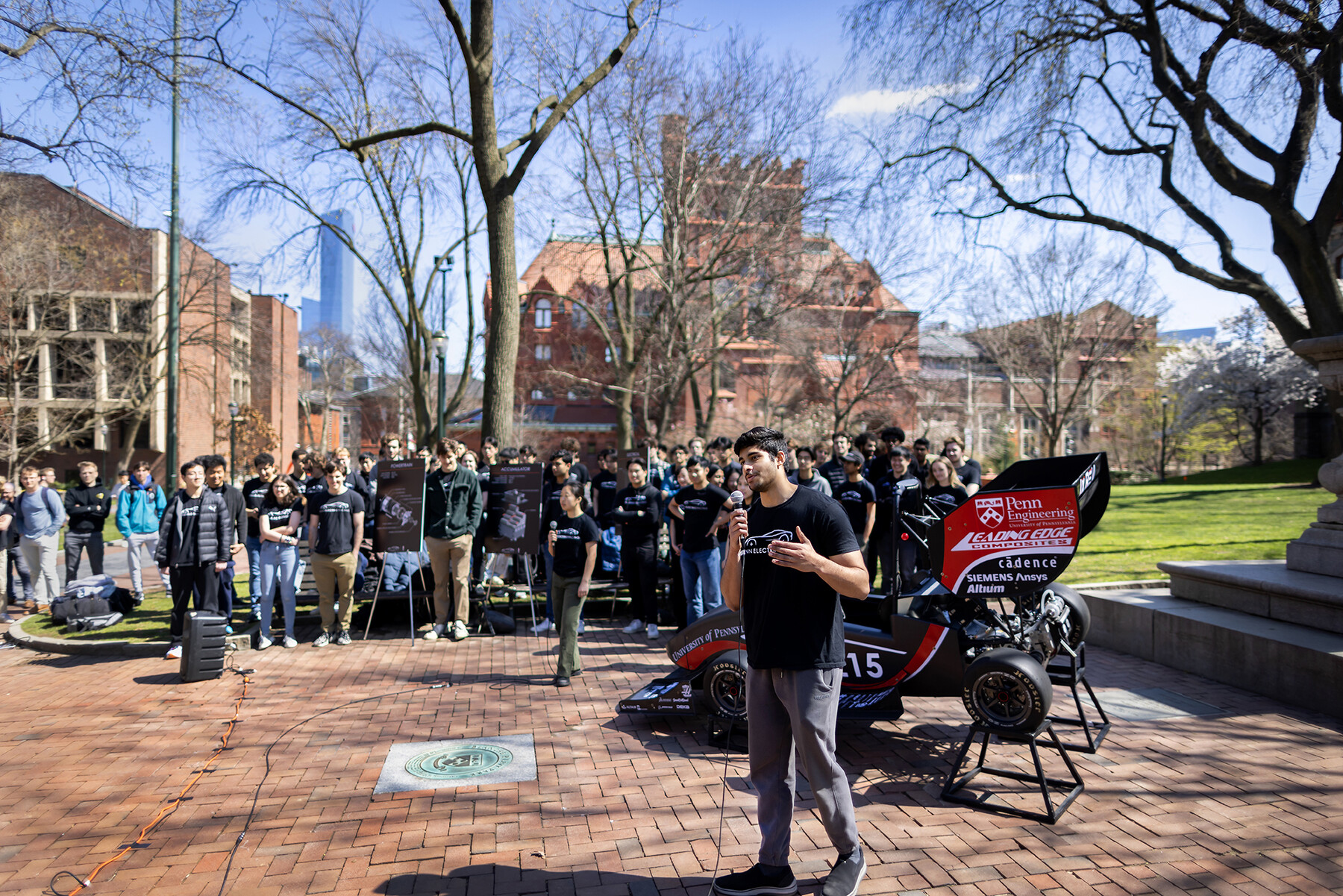 Rohan Maliekkal stands in front of electric racecar.