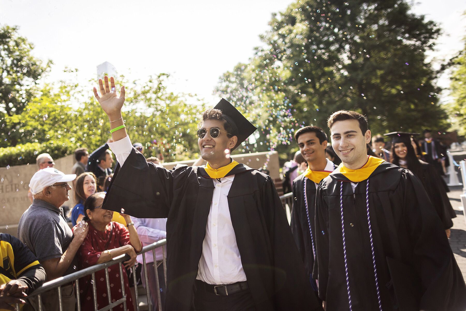 graduates walk over the penn park bridge