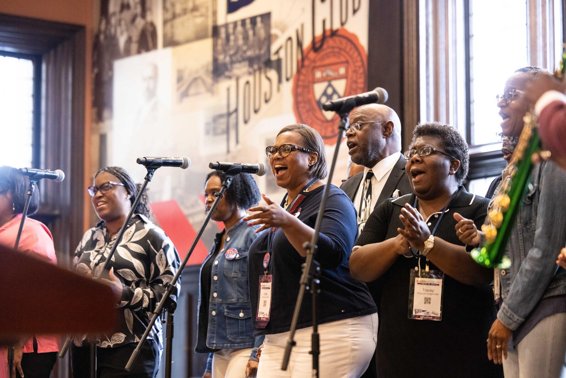 alumni singing into microphones