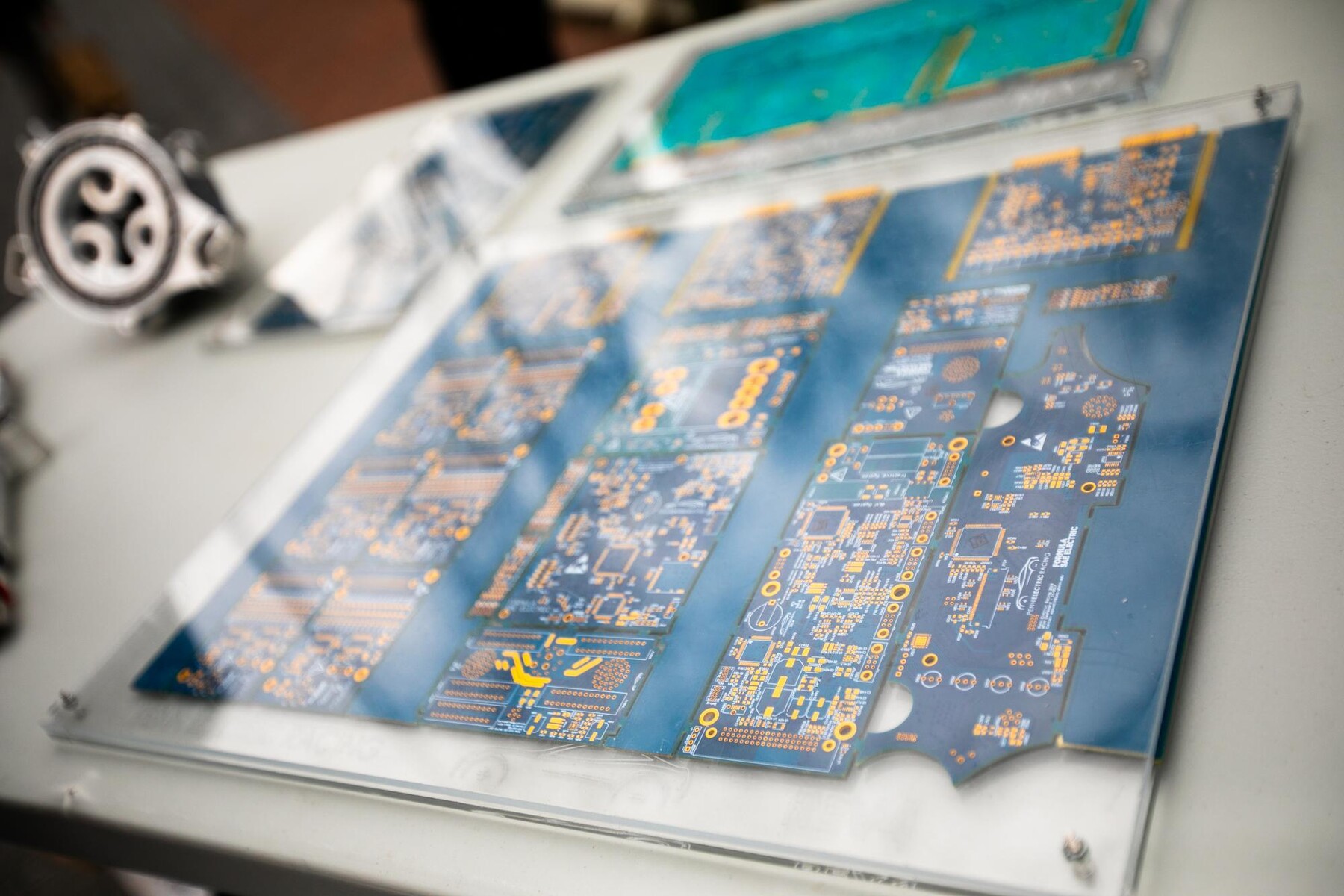 A close-up view of several intricate printed circuit boards displayed under a protective transparent cover.