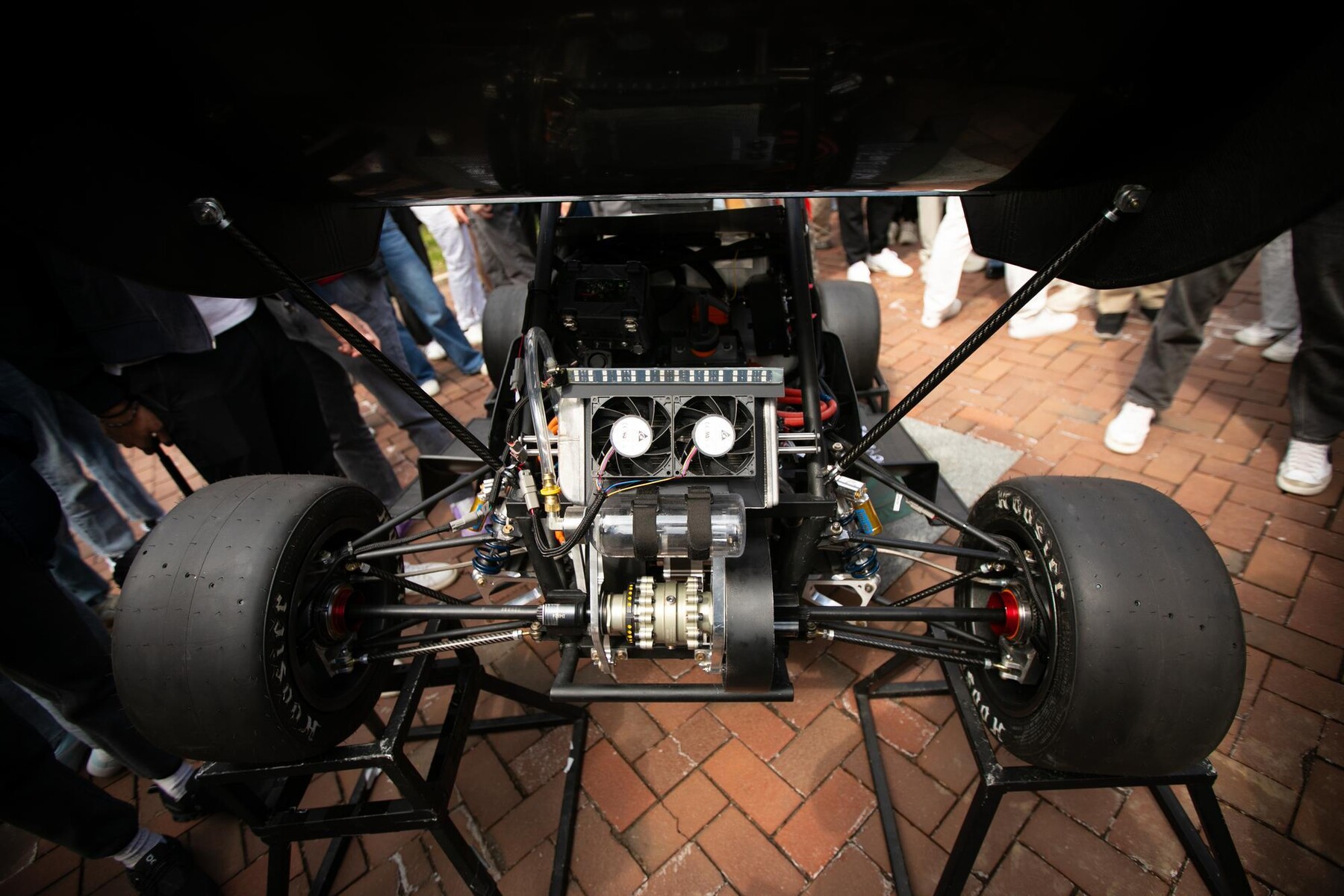 A detailed rear view of the REVX race car showcases its drivetrain, wiring, and internal electronics.