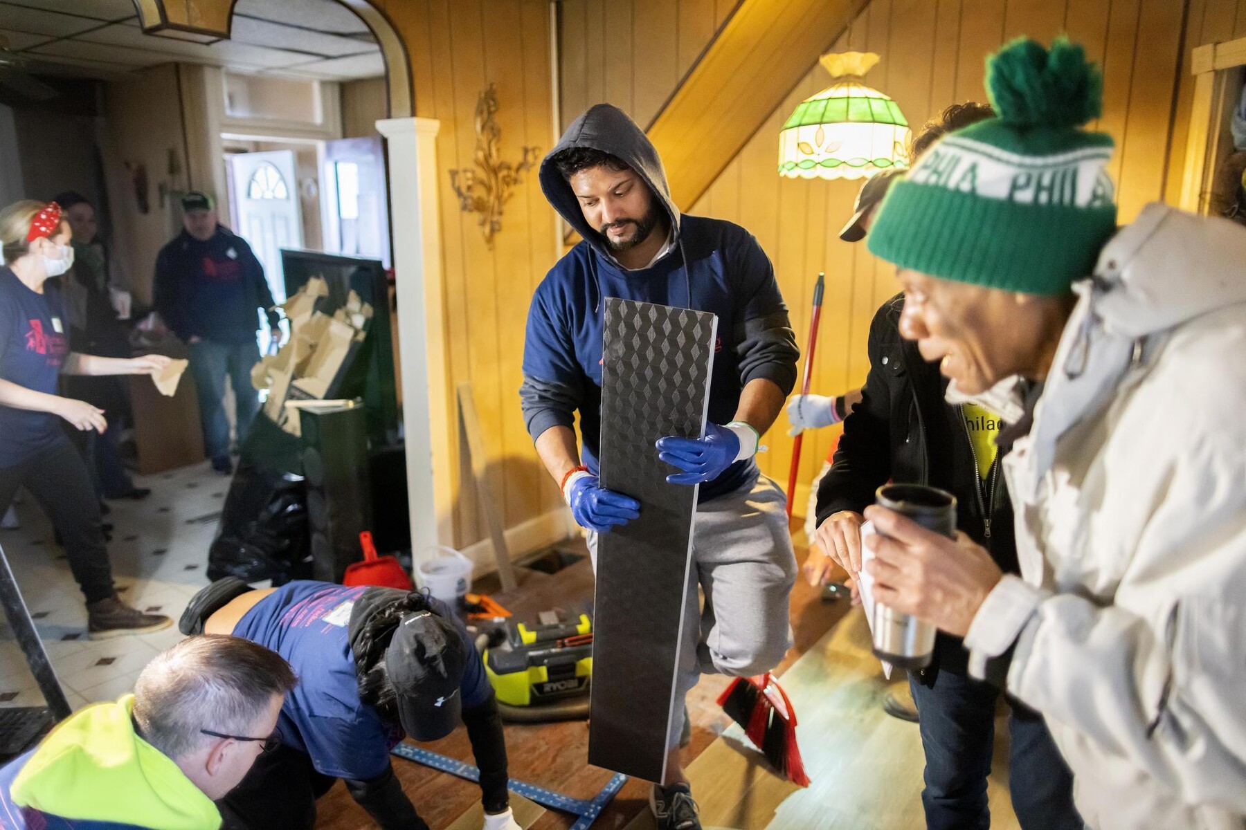 Volunteers taking floor tile measurements inside Rudy Edge's home.